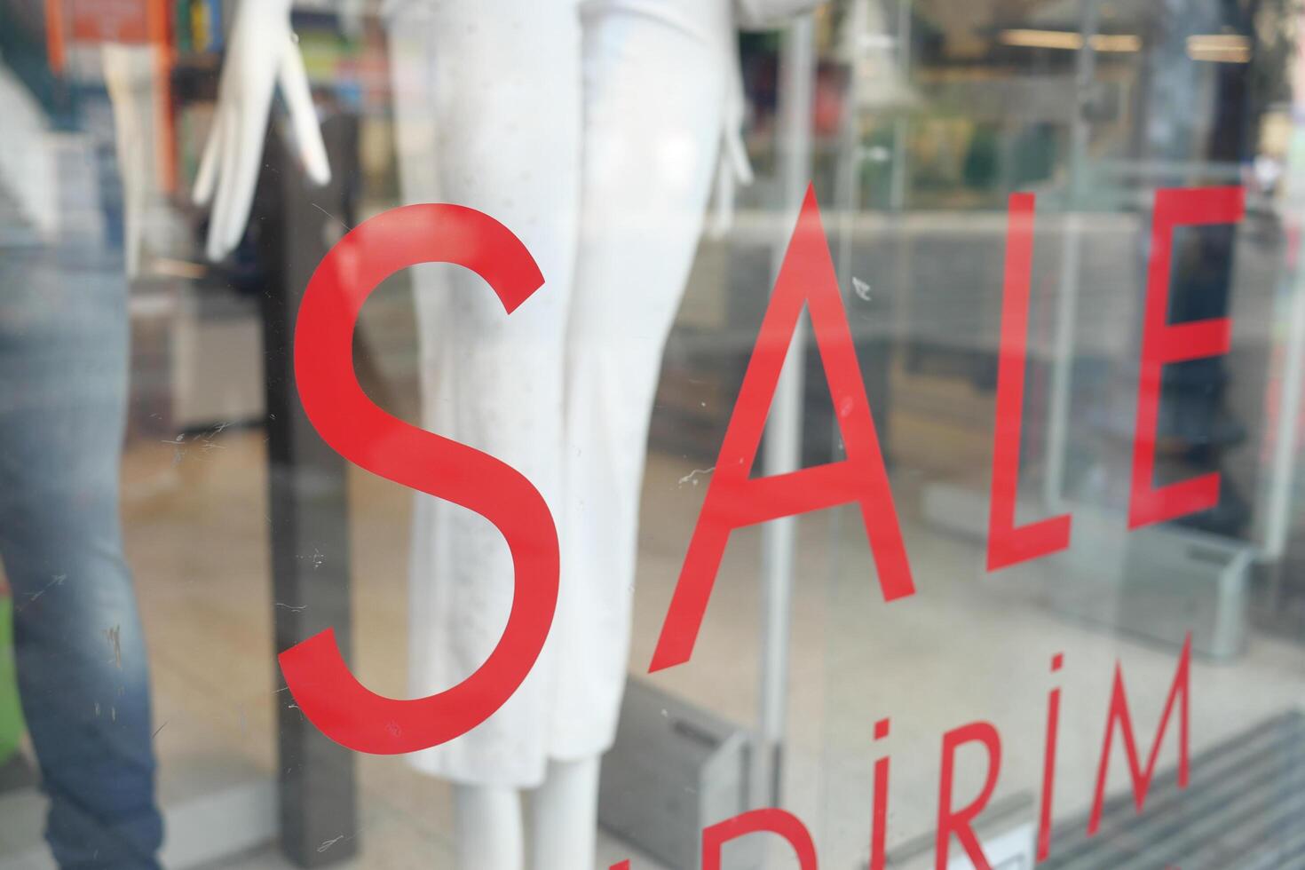 Large red Sale text letters on a glass wall obstruct a view inside the popular fashion store photo