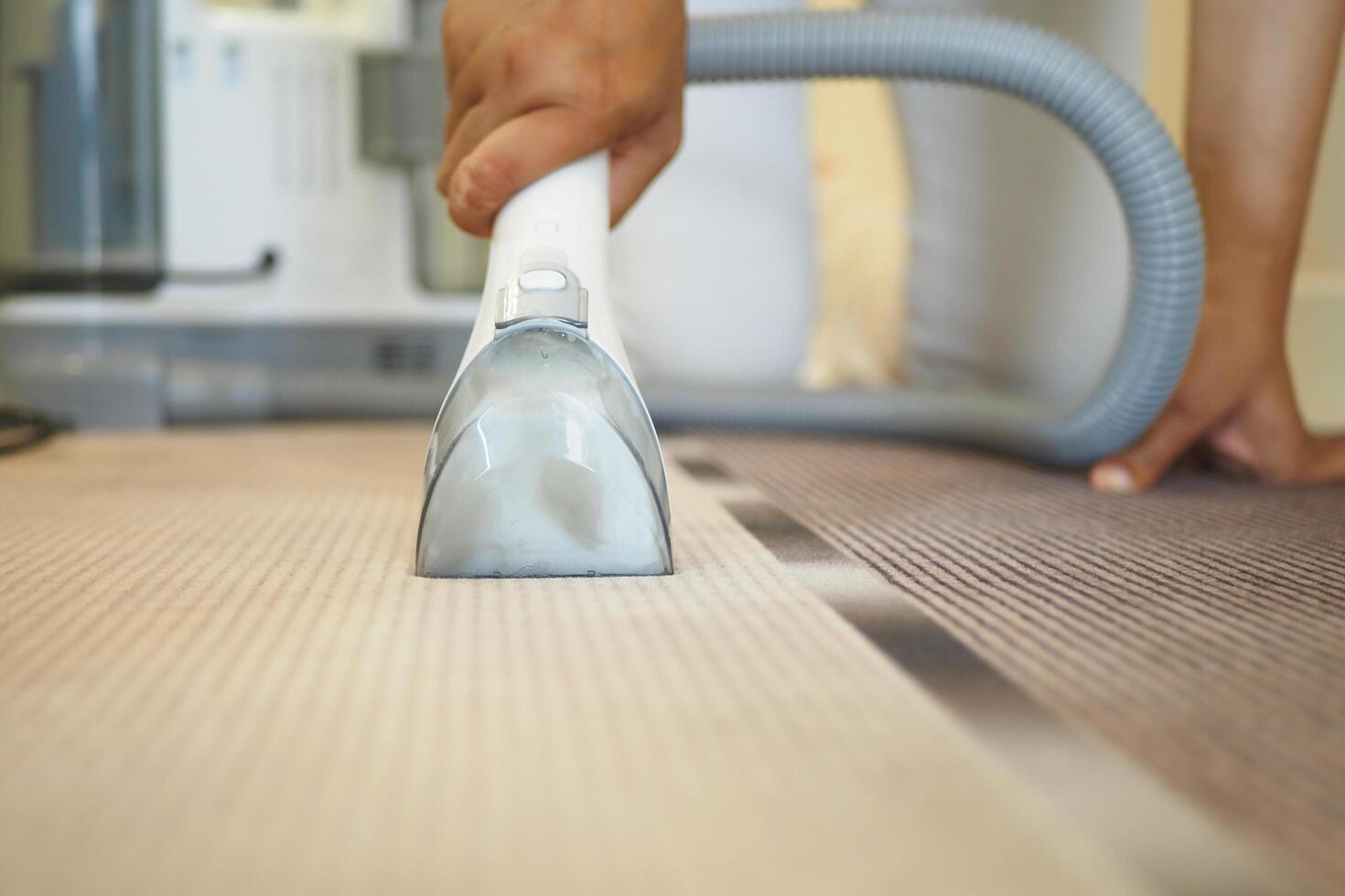 A CloseUp View of Vacuuming a Carpet in a Contemporary Living Room Environment Today photo