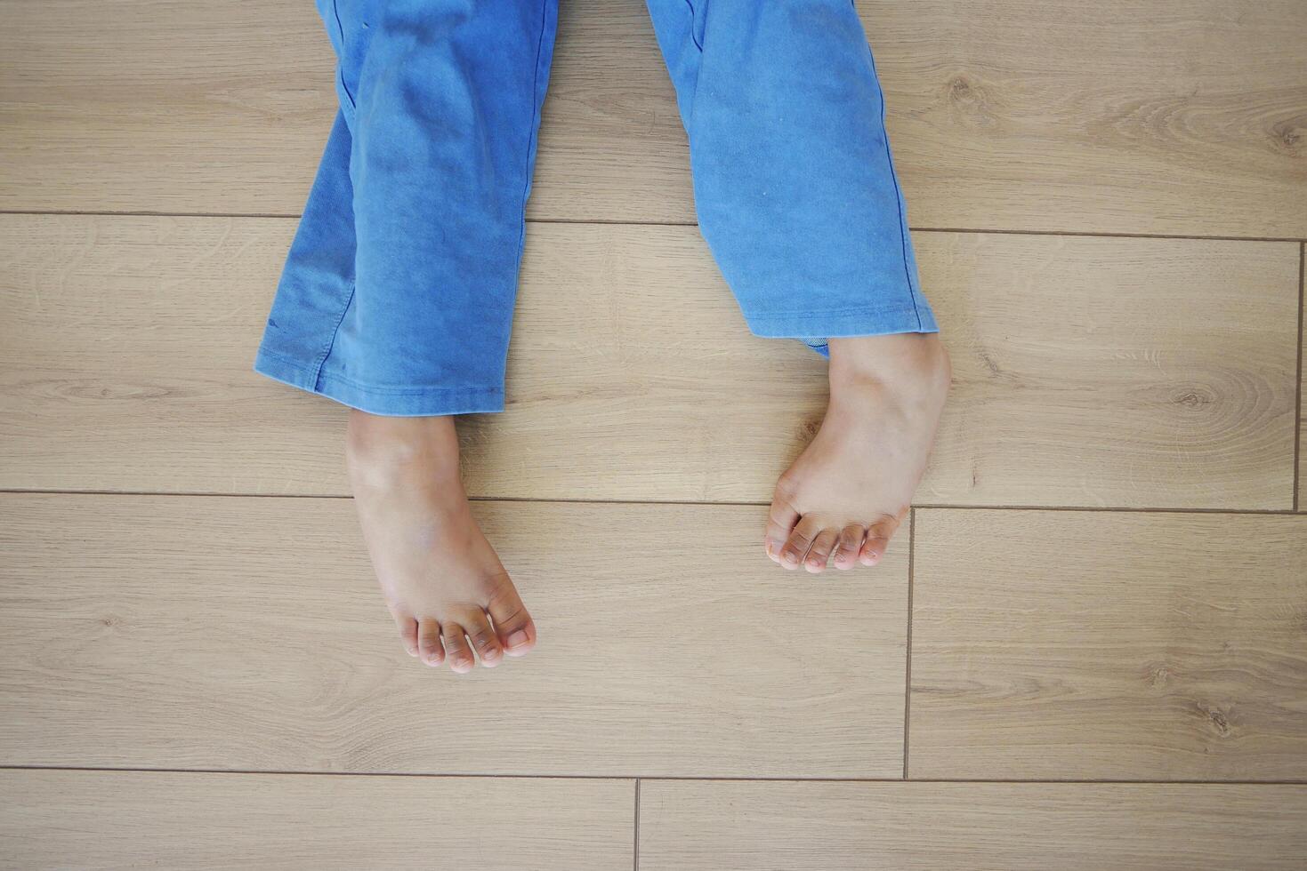 Bare feet of a child on a wooden floor represent innocence and playful moments at home photo