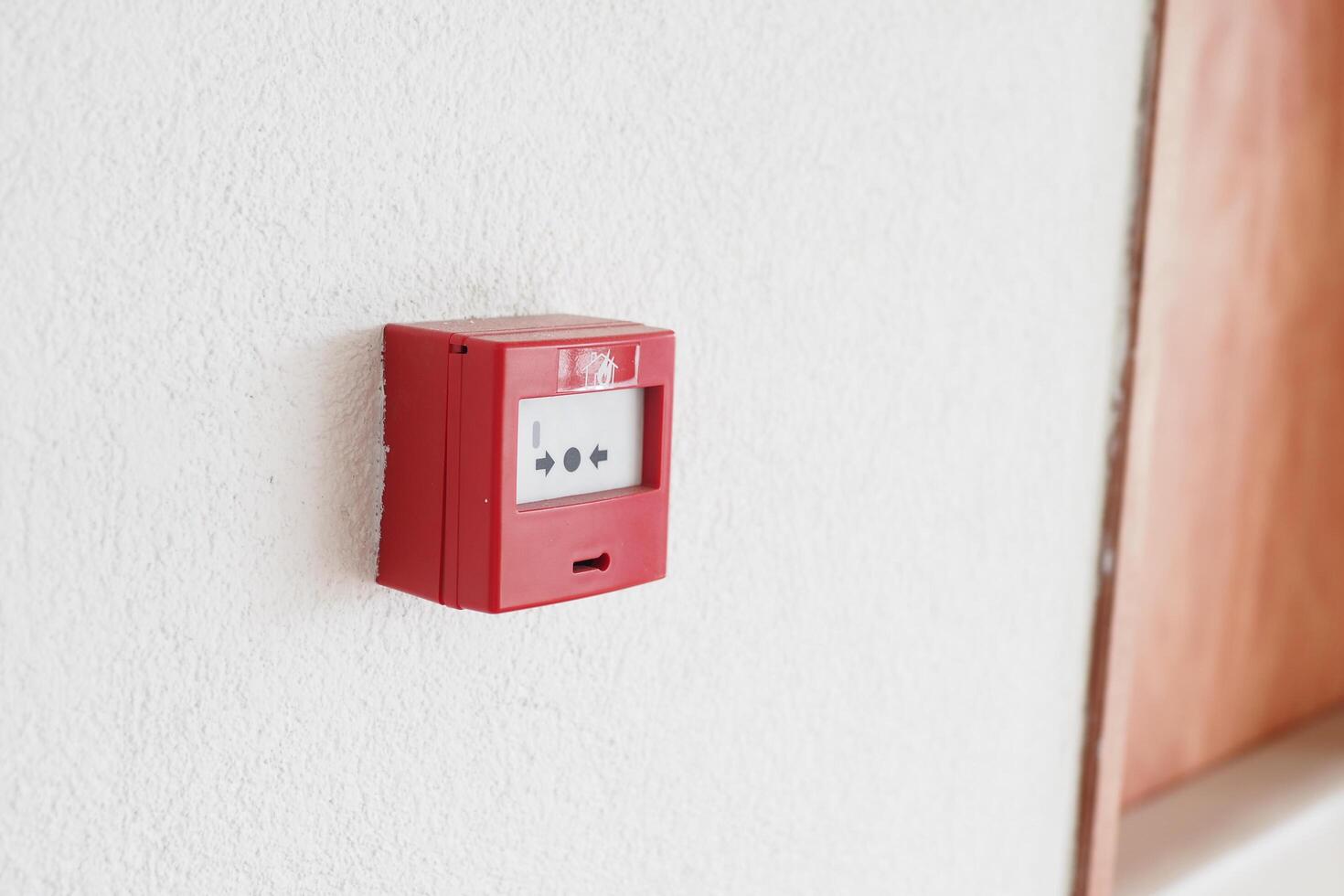 Red fire alarm button on wall , photo