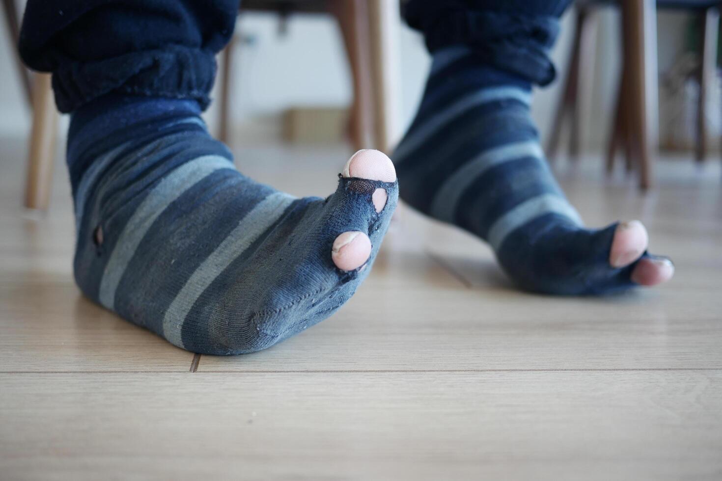 men feet with dirty socks while sitting on sofa photo