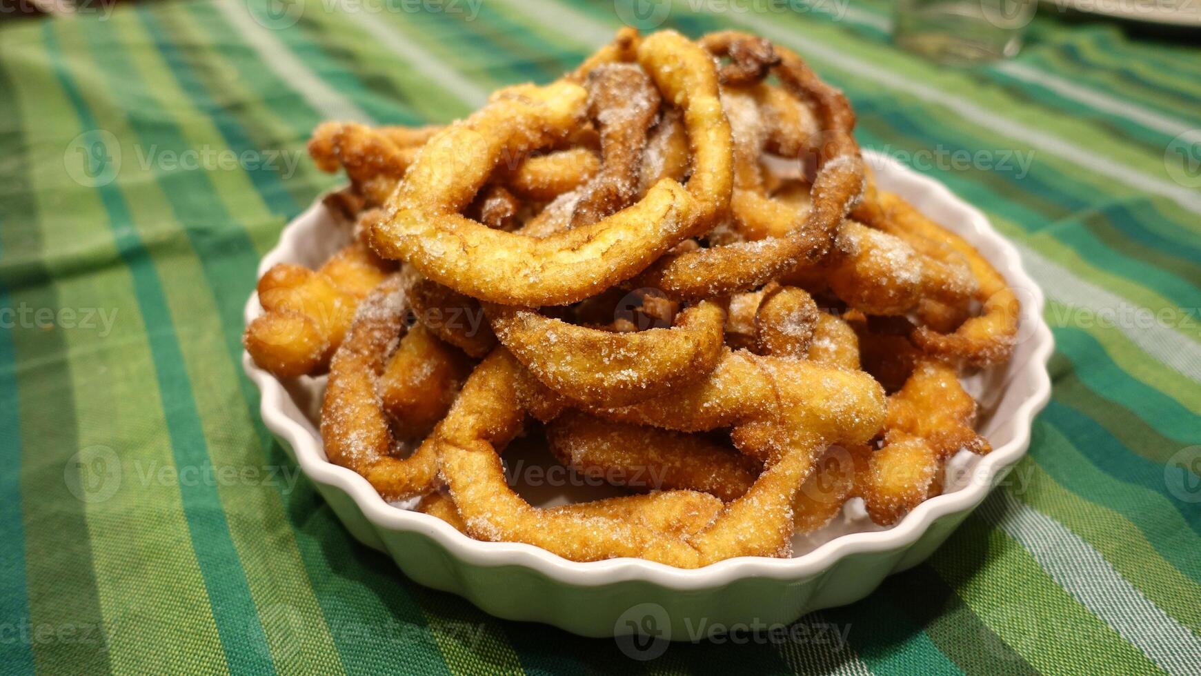 A tray of fried dough snakes with sugar ready to eat. Italian tradition. photo