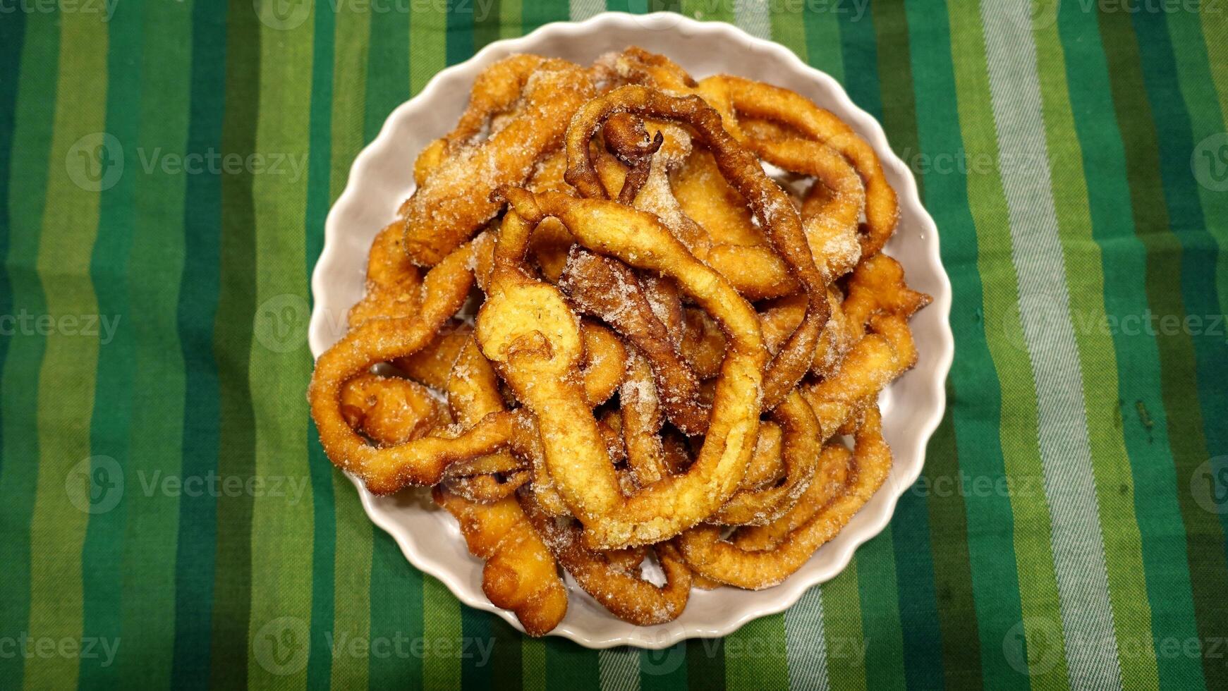 A tray of fried dough snakes with sugar ready to eat. Italian tradition. photo