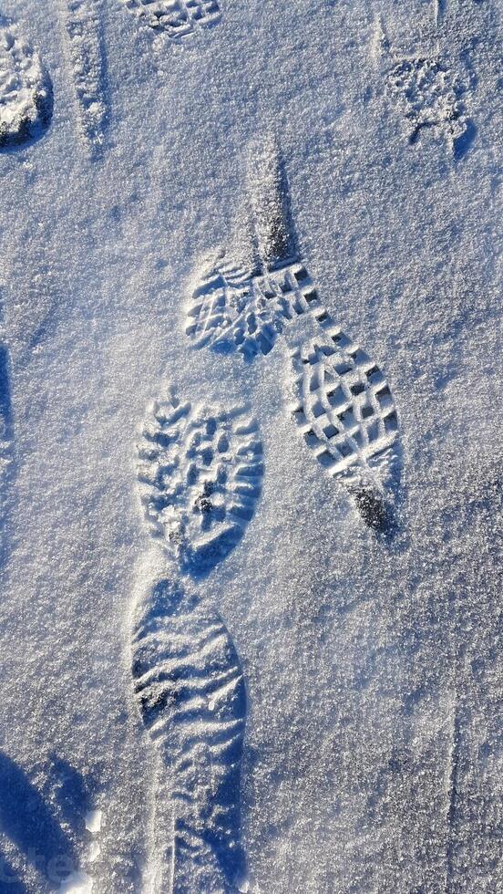 Footprints on a frozen lake in the mountains during a hike. photo
