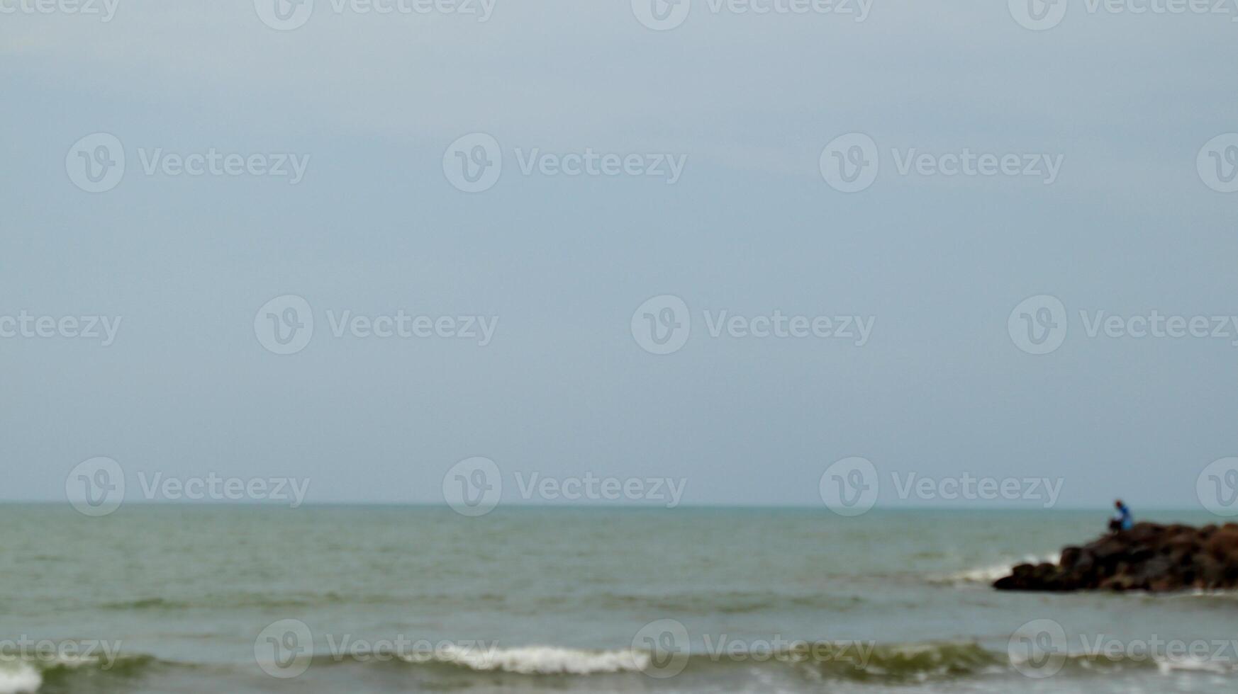 Fisherman standing at the seashore photo