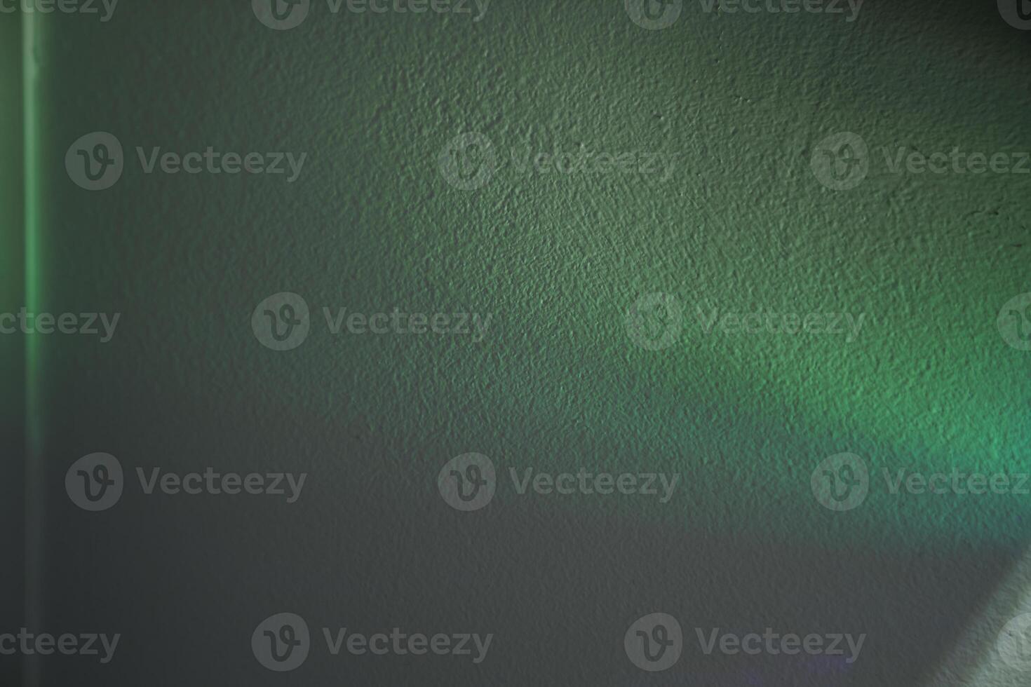 Green lights through the foil. Holographic abstract background in green tones. Lights on the wall with copy space. photo