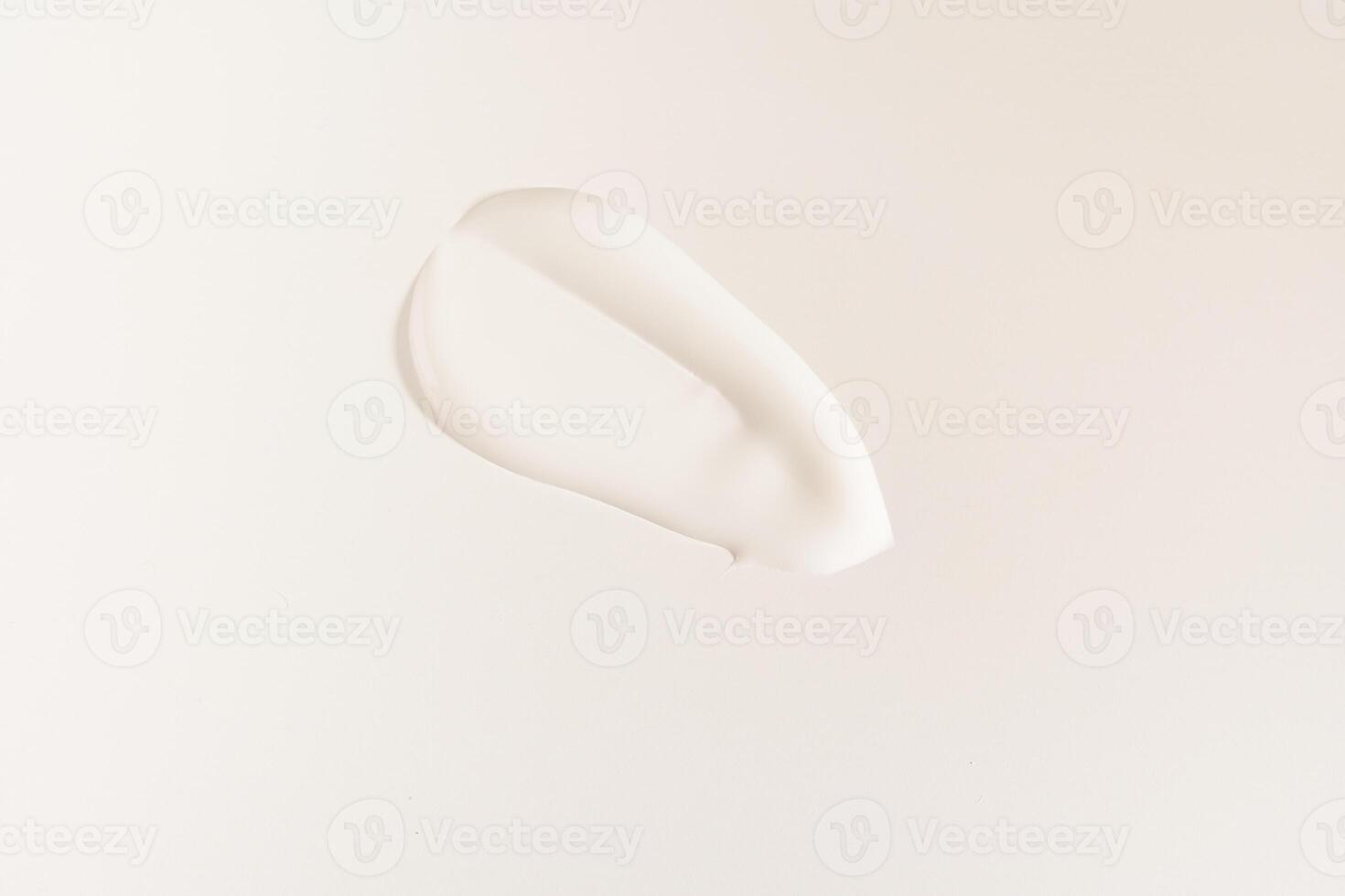 A smear of cosmetic cream. A white creamy drop of skin care cream. Fresh, smooth brushstroke isolated on a white background with space to copy photo