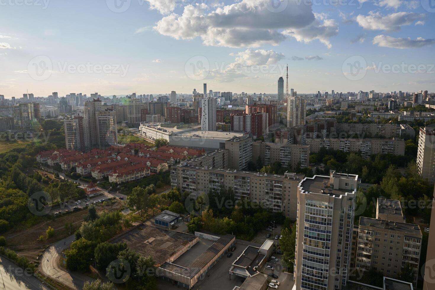 Apartment buildings in the background. Dense buildings of the city visible from above. Blue sky with clouds. RUSSIA - August 14, 2022, high-rise buildings from a height. photo