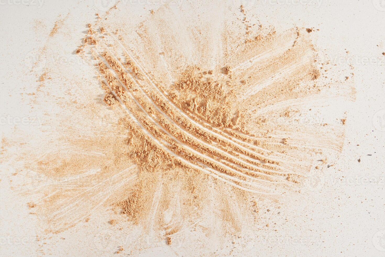 Face powder of neutral color, scattered on the surface on a light background. Top view, flat position. Gold powder layout with a space to copy. photo