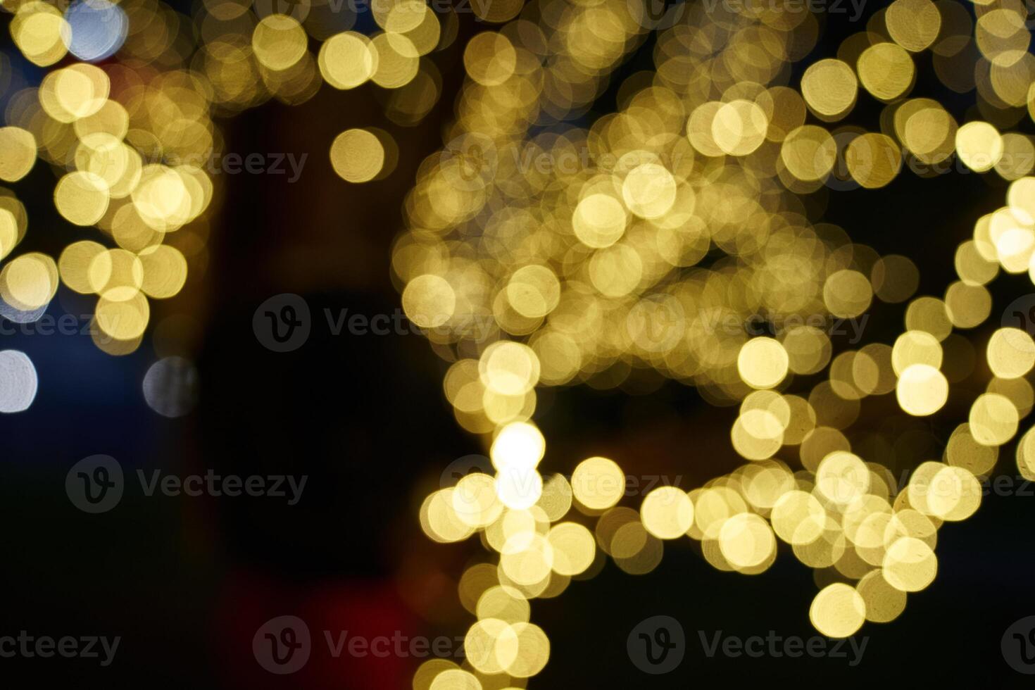 Abstract glowing bokeh lights highlighted on a black background. Festive golden glowing background with yellow lights. Overlay bokeh for your design photo