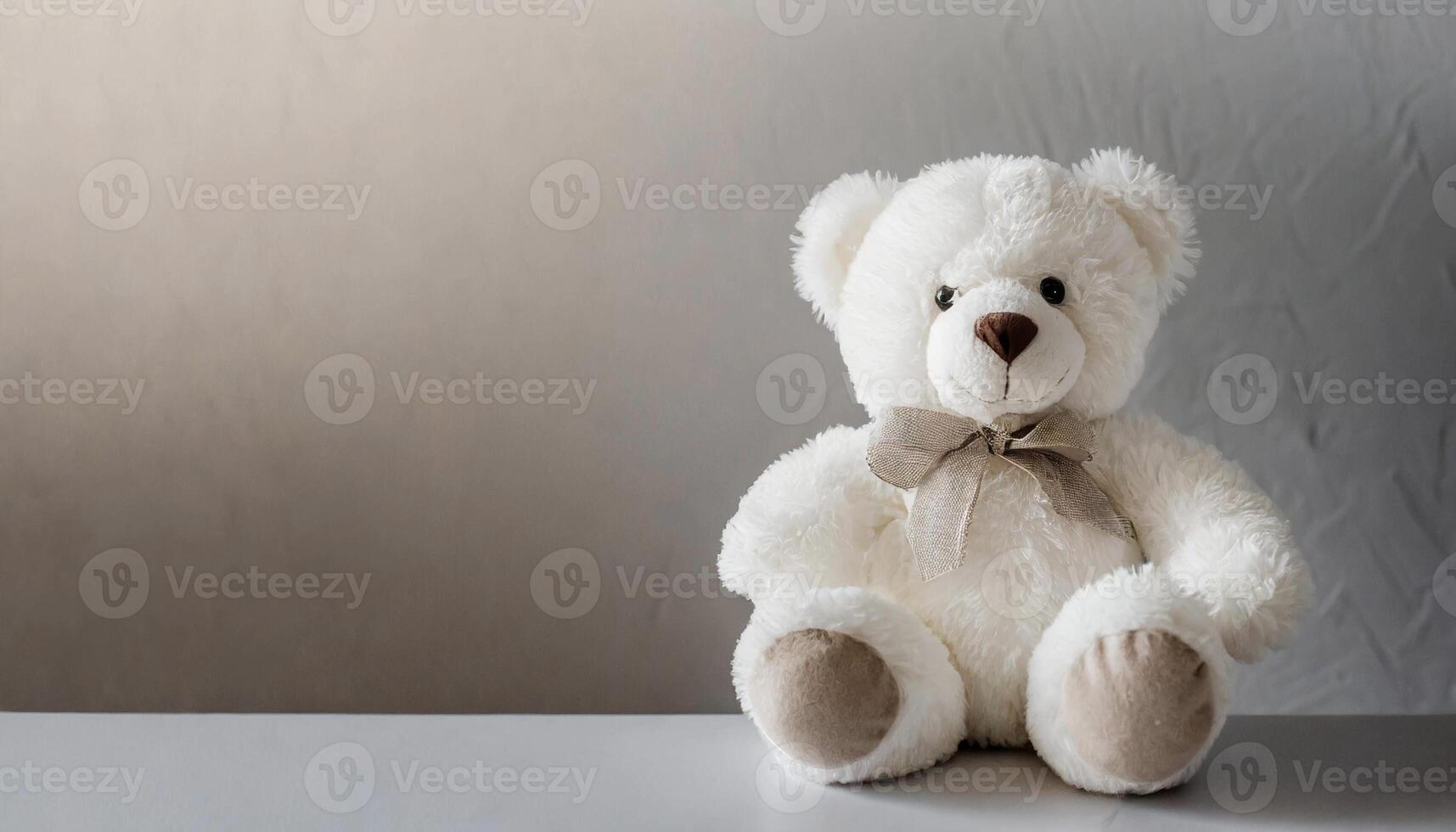 Close-up of beautiful teddy bear sitting, children's plush toy. Gray background. photo