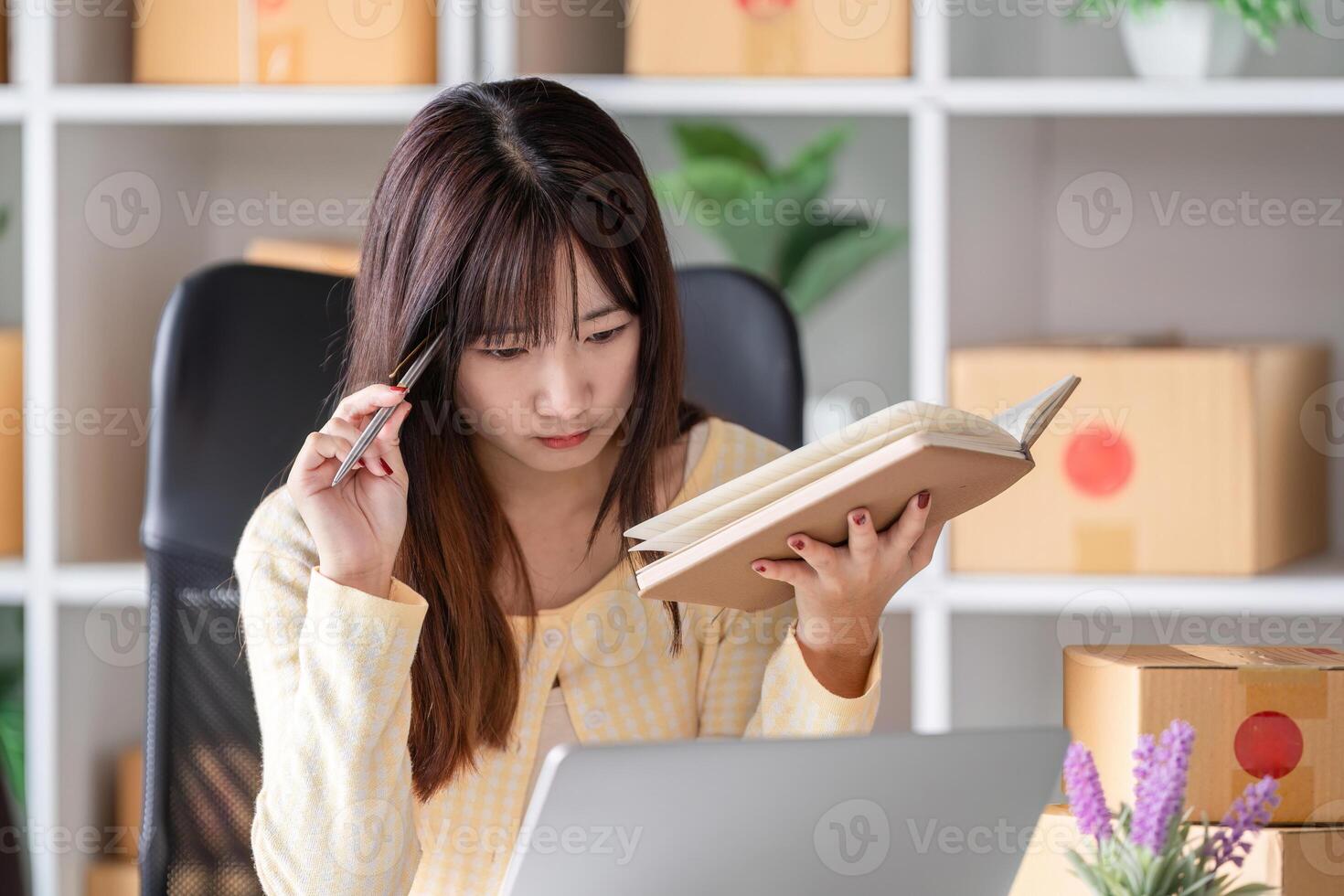 Young Woman Stressed About Selling Items Online, Working at Home Office with Laptop and Notebook photo