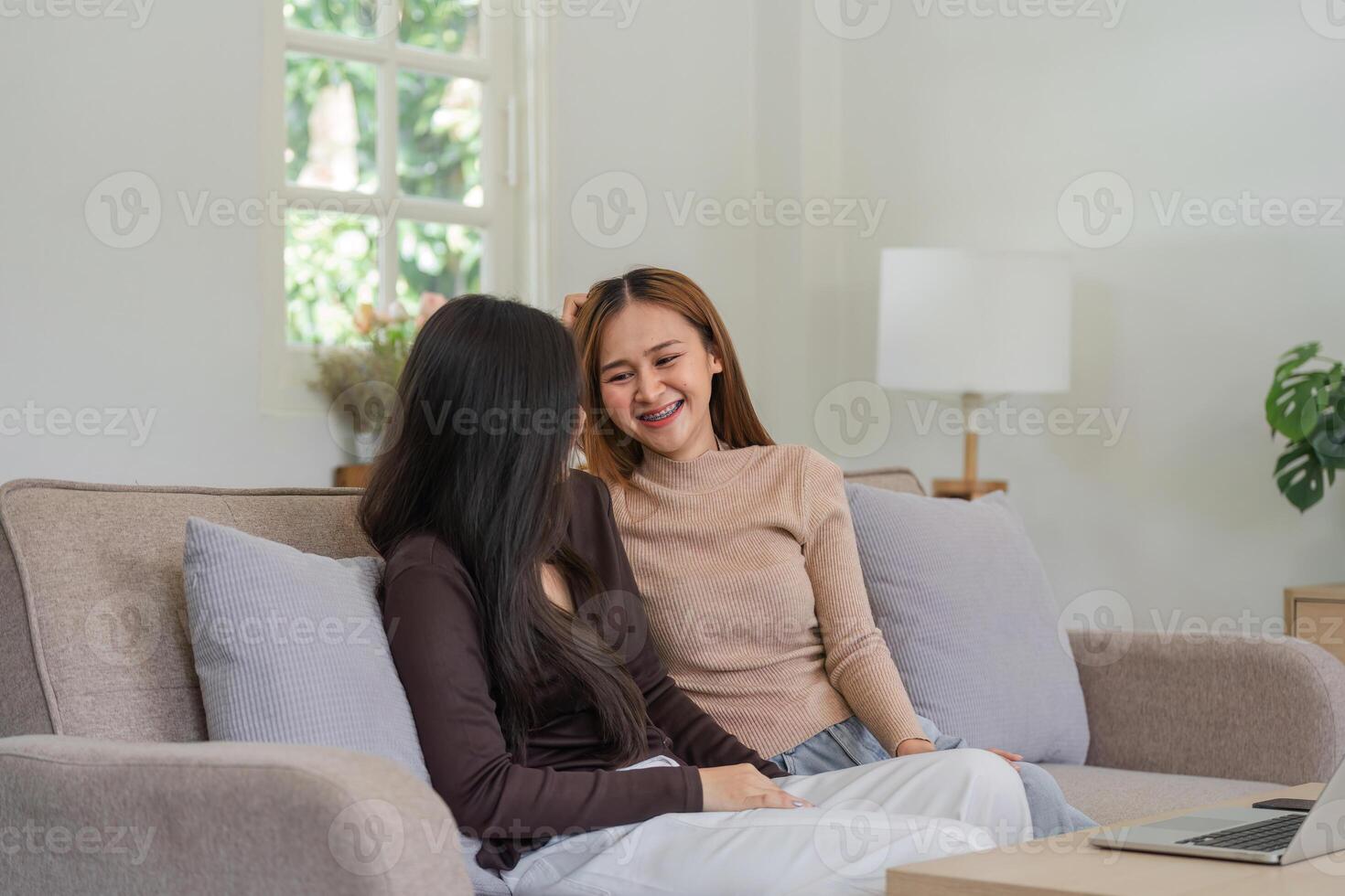 Happy Lesbian Couple Sitting Together on a Cozy Sofa at Home, Enjoying Quality Time and Smiling photo