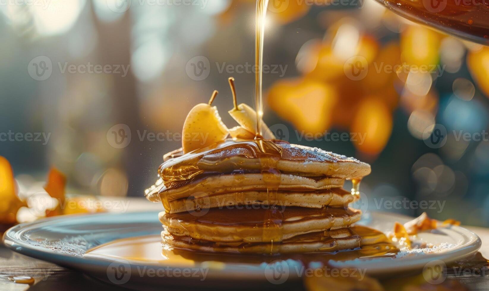 Apple syrup being poured over a stack of pancakes photo
