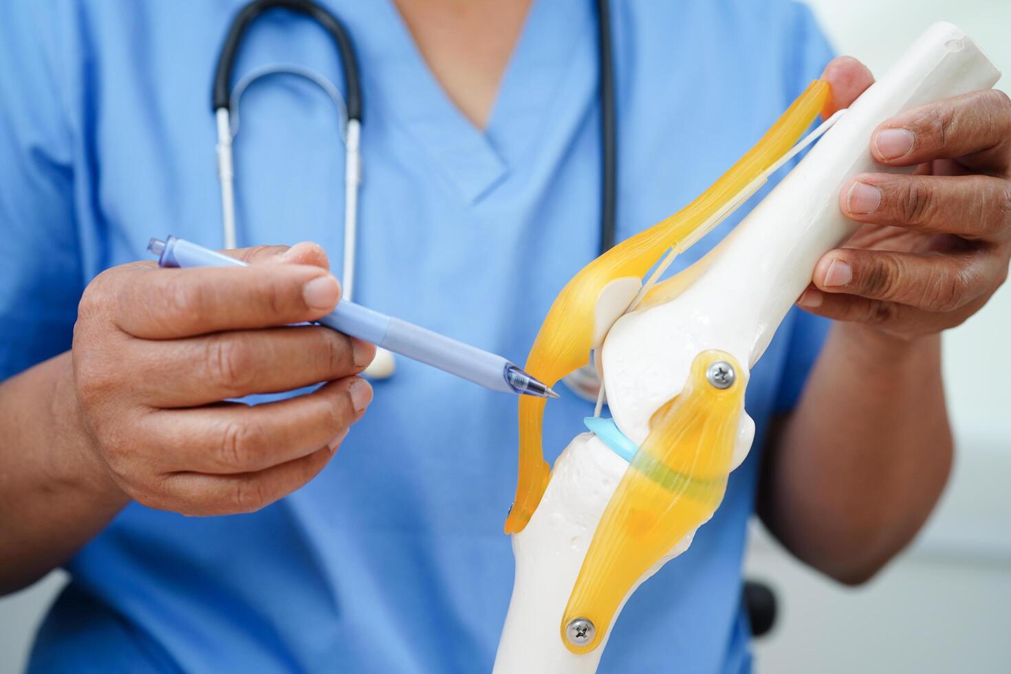 Asian doctor holding spinal nerve and bone model, Lumbar spine displaced herniated disc fragment for treatment medical in the orthopedic department. photo