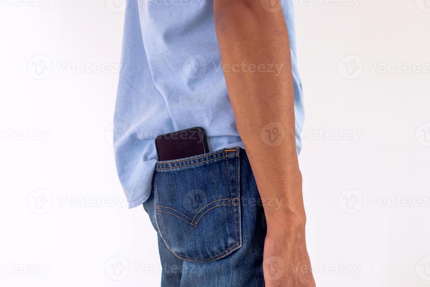 Man put a smartphone in back pocket of his jeans. Beware of pickpockets concept. photo