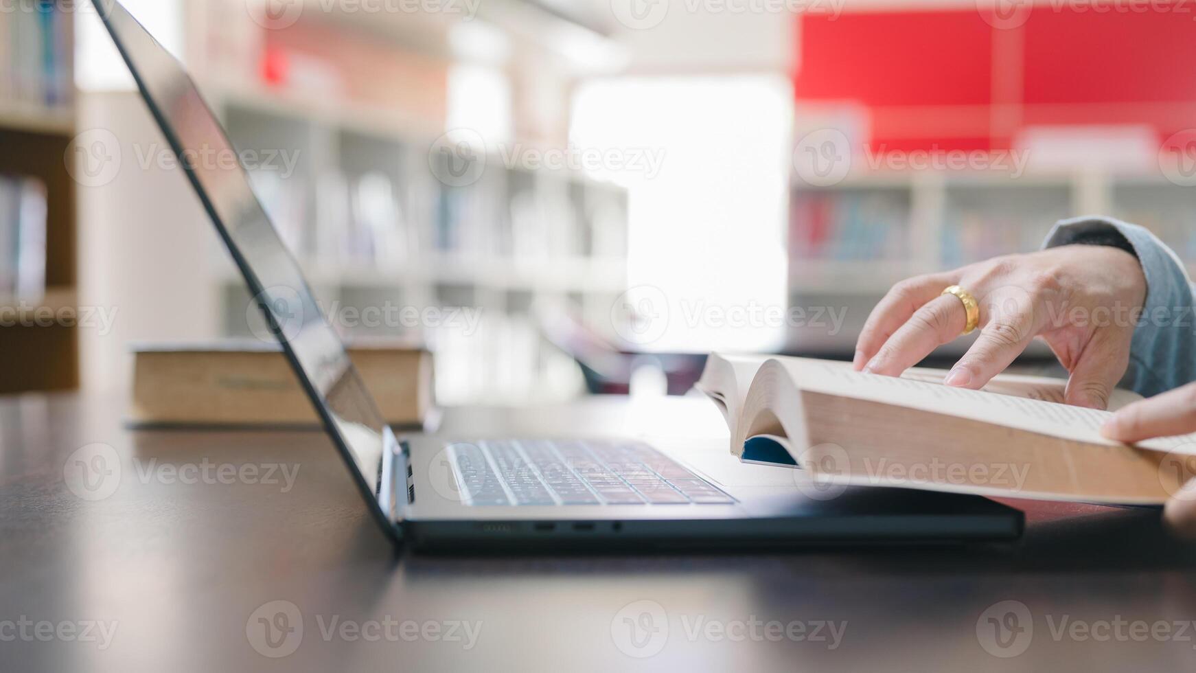 Man read book concept. A person is using a laptop and a book on a table. The person is likely studying or working on a project. education, school, learning, student photo
