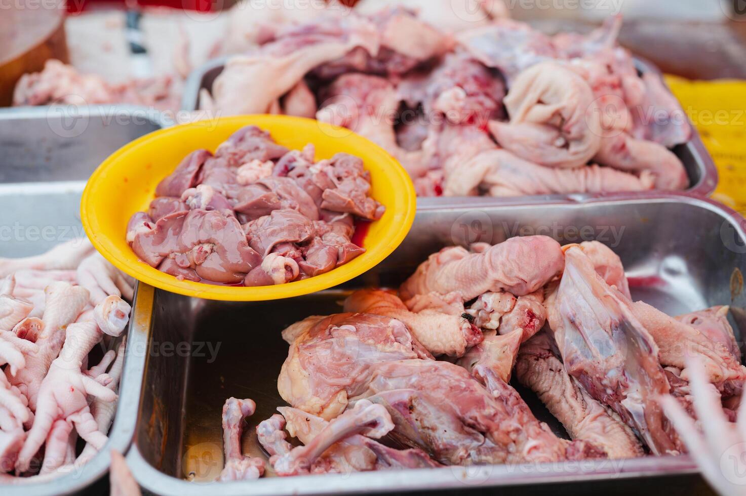 A pile of chicken meat is displayed in a yellow bowl. The meat is cut up and ready to be cooked photo