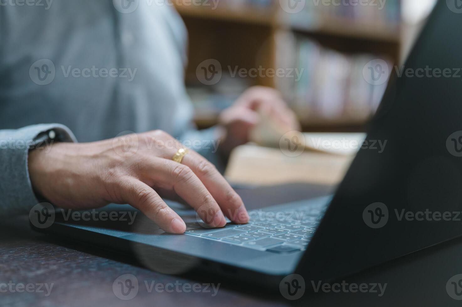 Man reads book concept. A man reads a book in the library, studying with his laptop, learning for success in business as a dedicated student. photo