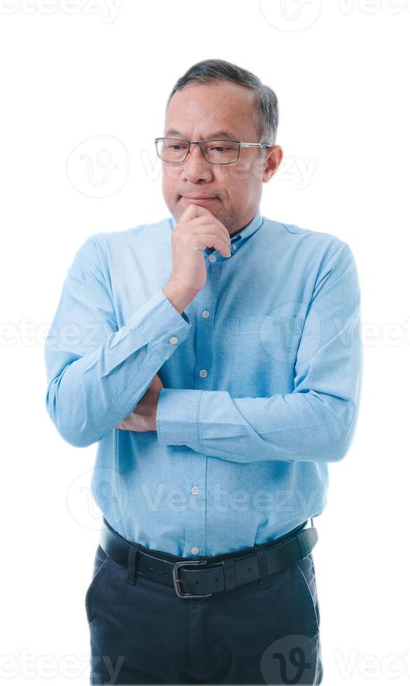 Asia man in a blue shirt and glasses is looking down and thinking. He is wearing a belt and has a beard photo