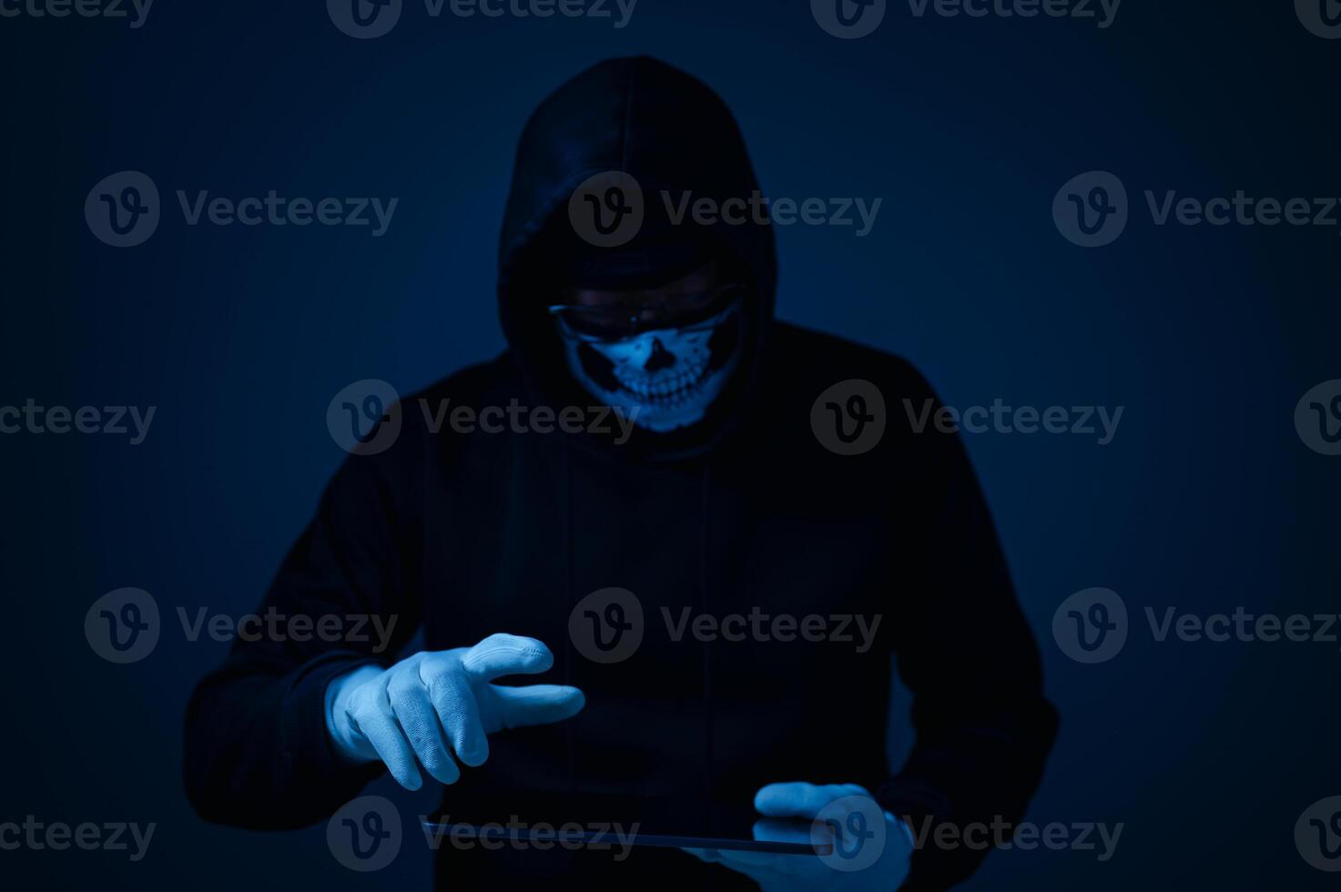 A hacker with a tablet, a criminal in the dark, uses advanced technology to spy and steal data, posing a serious security threat as a modern-day tech-savvy thief. photo