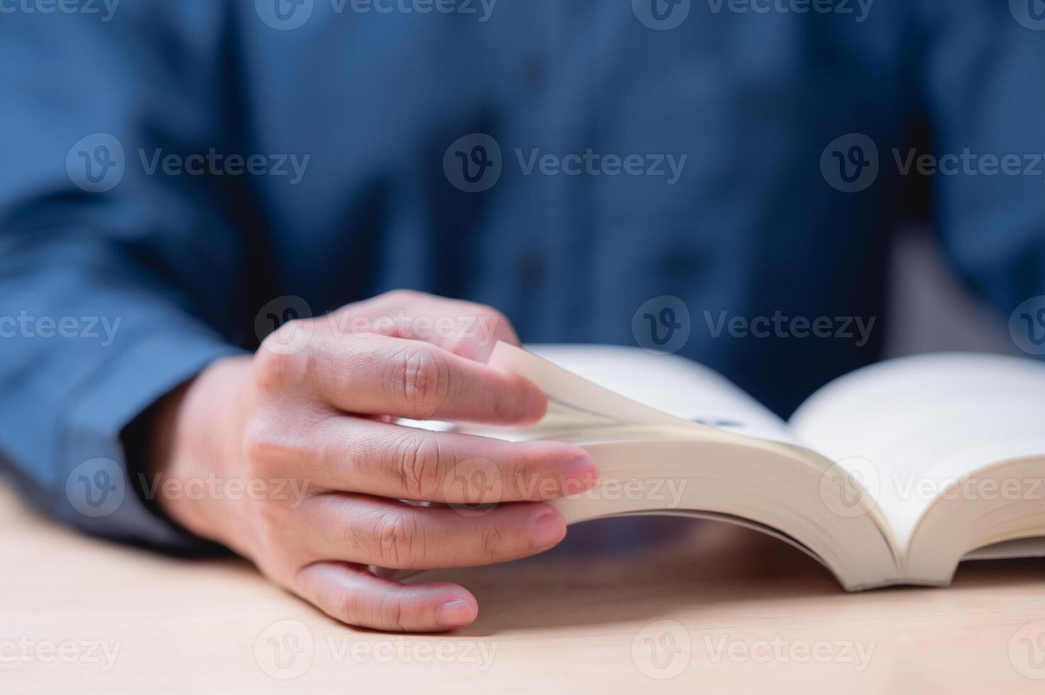Reading and learning book concept. A man is reading a book with his hand on the page. The book is open to a page with a picture of a person photo