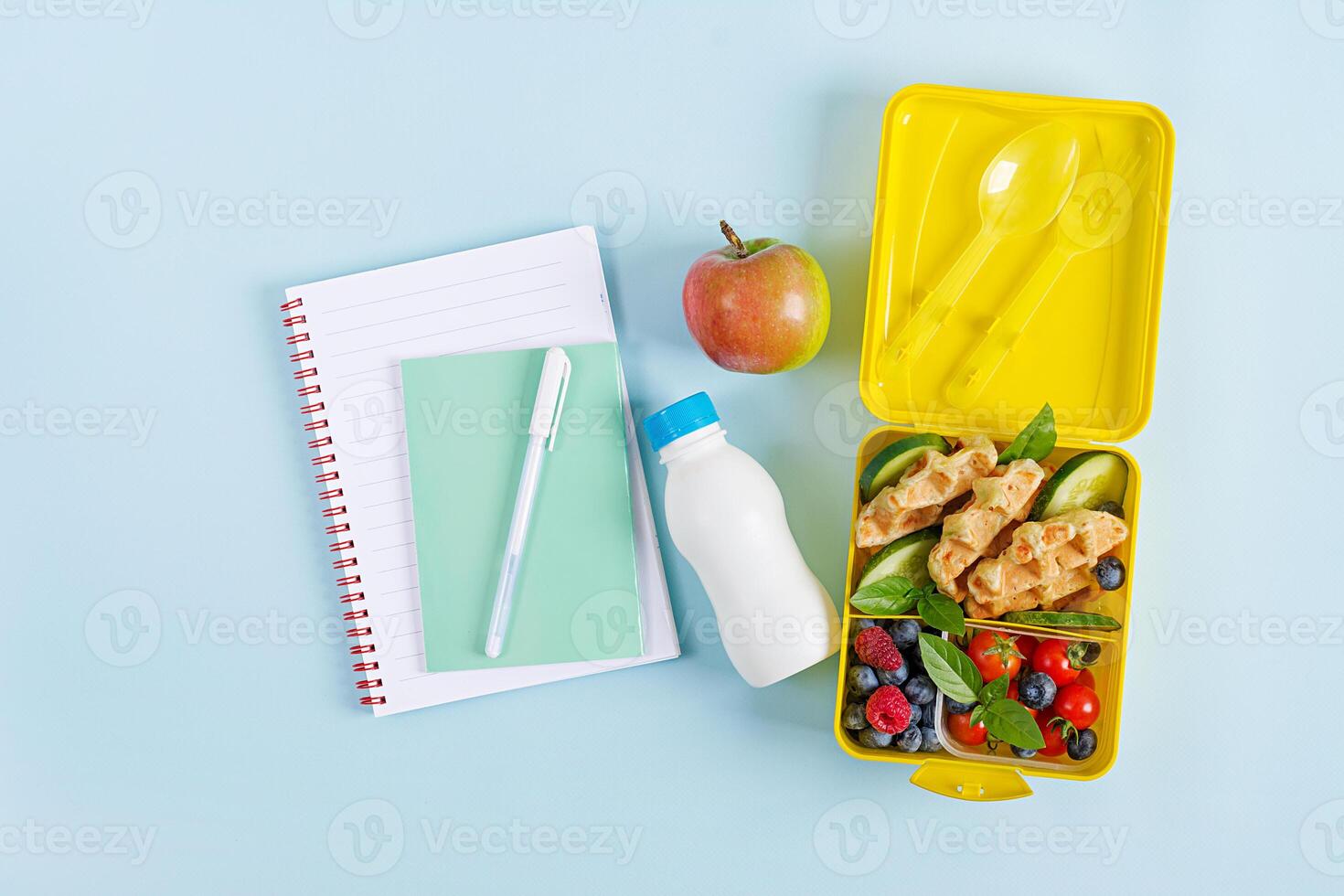 Kids lunch box with zucchini waffles, cucumber, cherry tomatoes and blueberries. Back to school breakfast background. Copy space. Top view, flat lay photo
