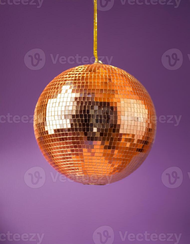 A disco ball hangs from the ceiling against a purple background photo