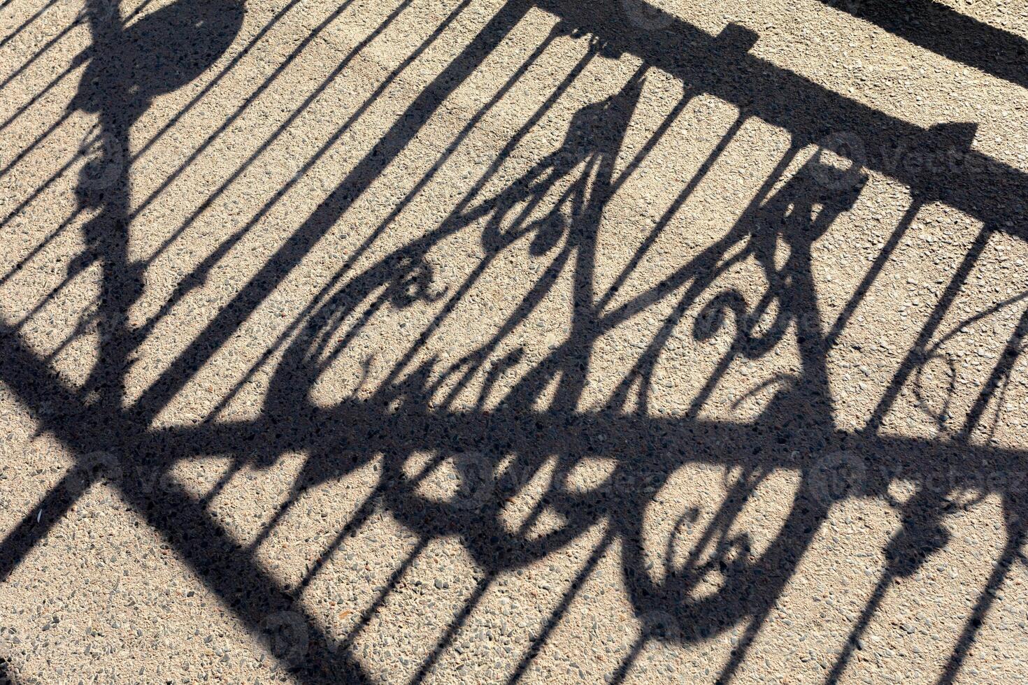 Light and shadow. Shadow of railing on the pavement photo