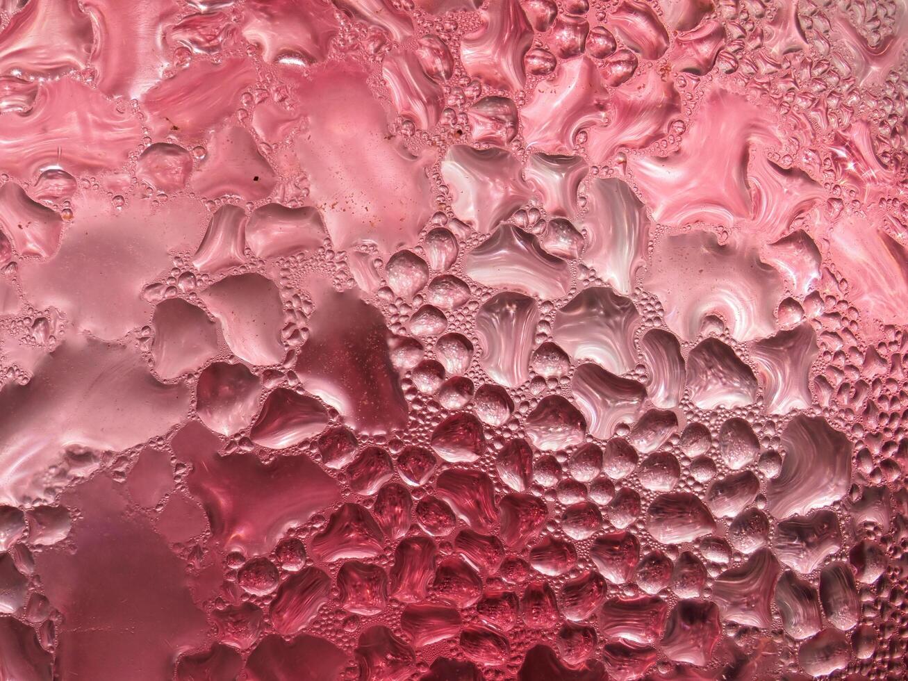 Drops of ice on a red cold drink glass photo