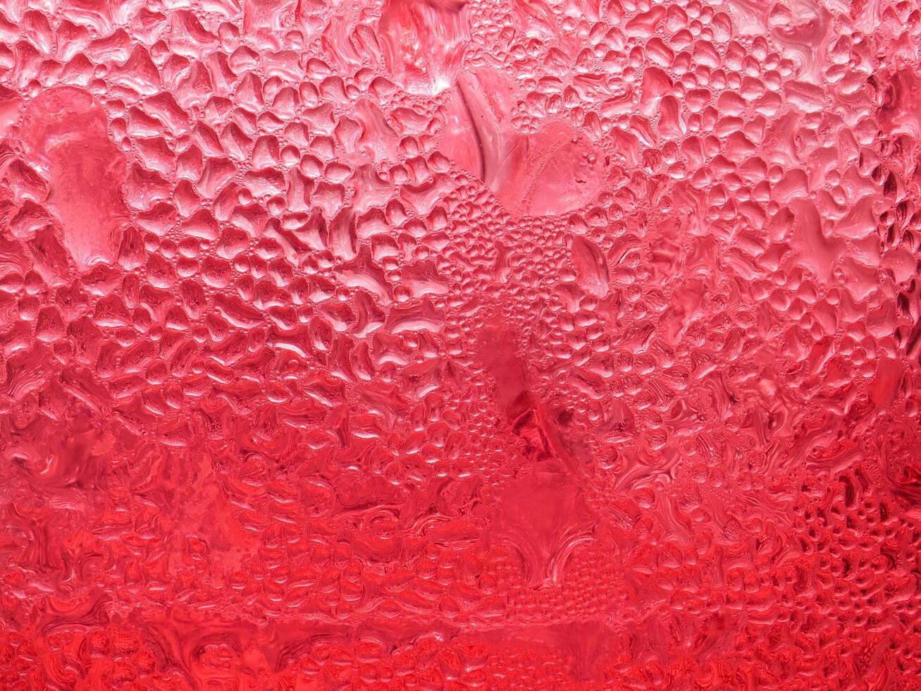 gotas de hielo en un rojo frío bebida vaso foto