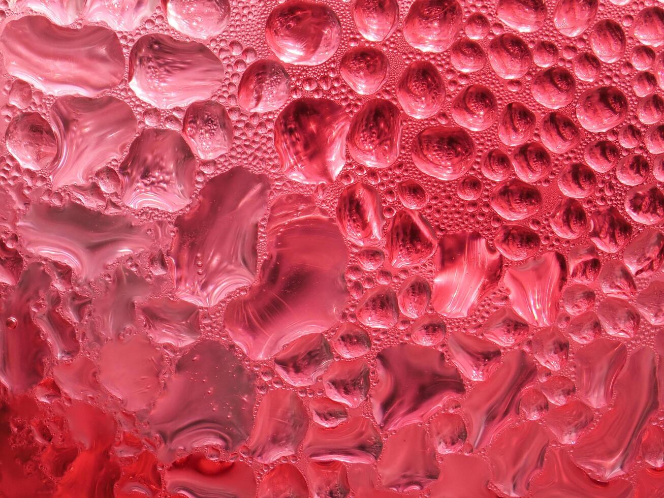 Drops of ice on a red cold drink glass photo