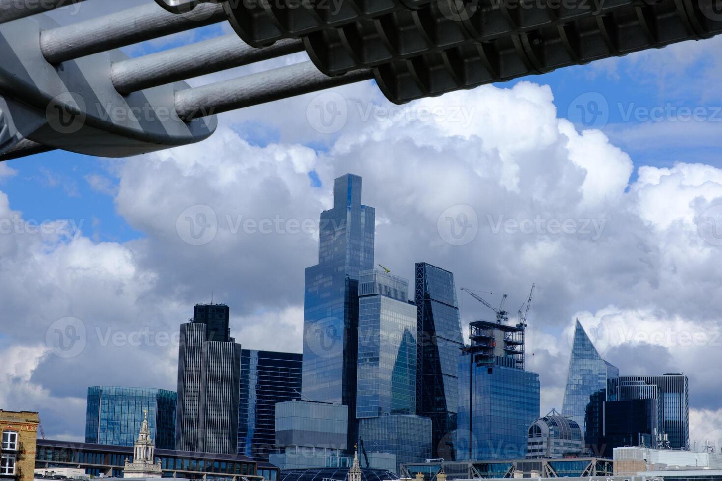 The City of London busines district framed by the Millennium footbridge set against a dramatic stormy sky, London, UK photo