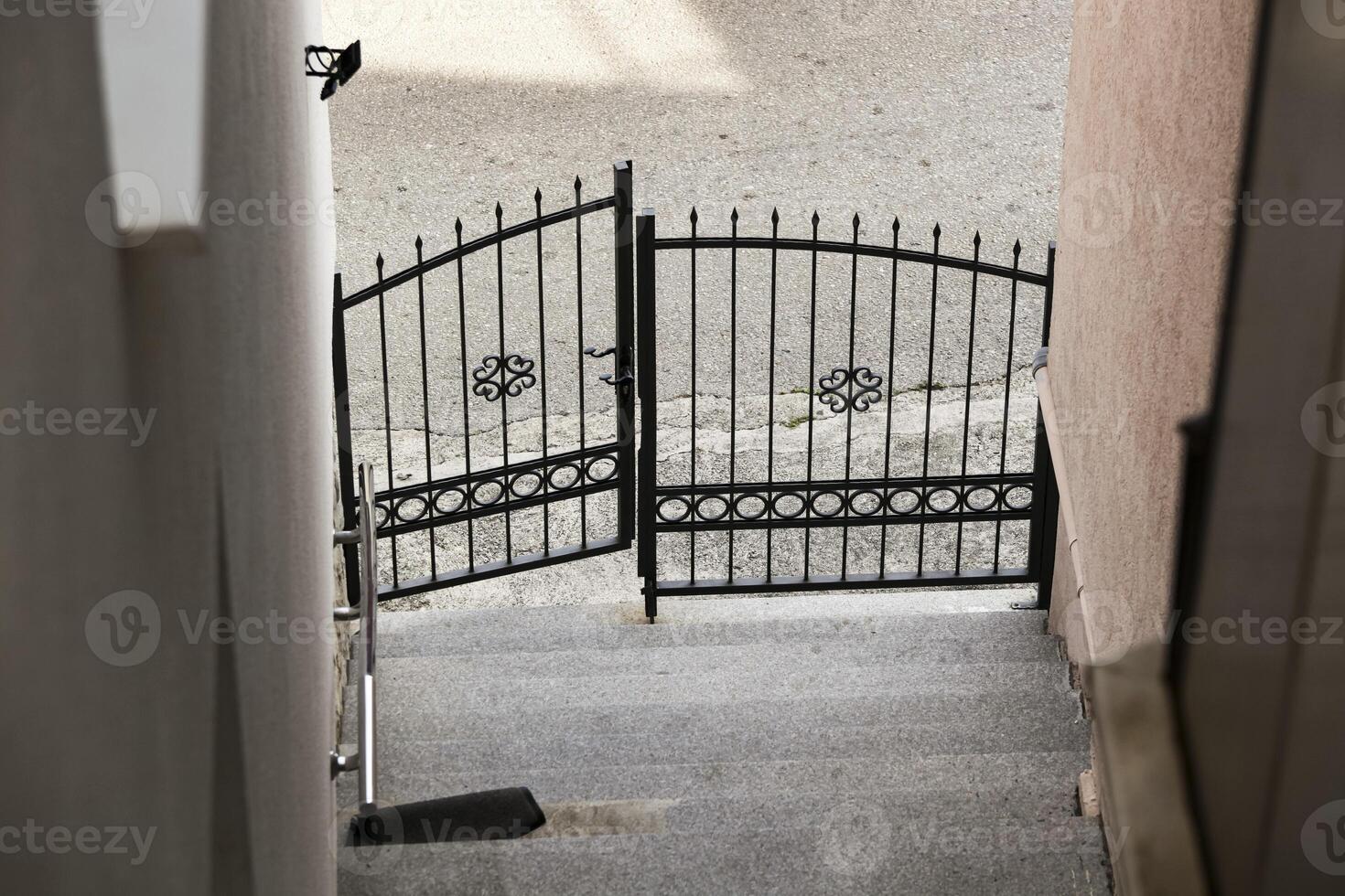 Grey steps in city and old metal gate. Detail of old staircase. Abstract wrought iron gate. Background photo