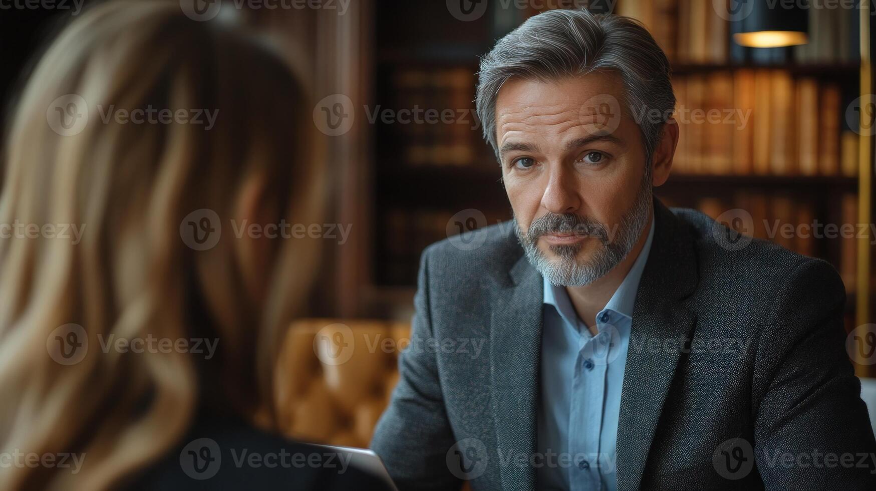 A businessman discusses important matters with a colleague in a warm library atmosphere photo