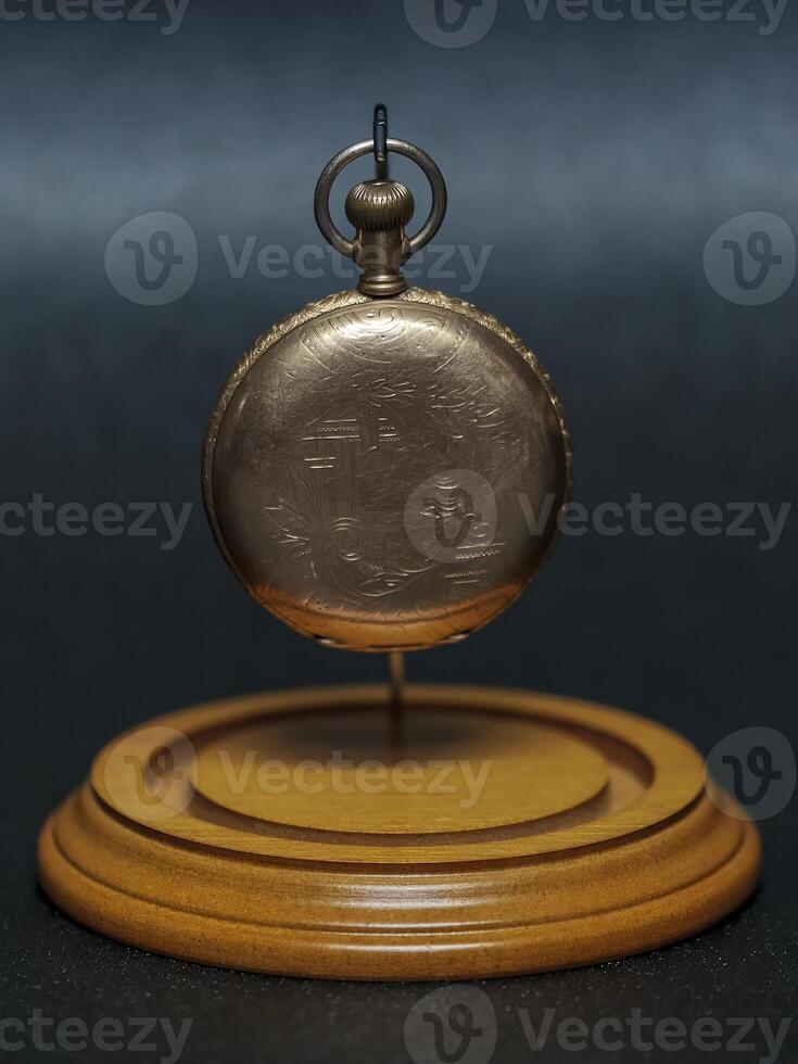 old pocket watch a family heirloom from several generations ago hanging in its display case with out the dome photo
