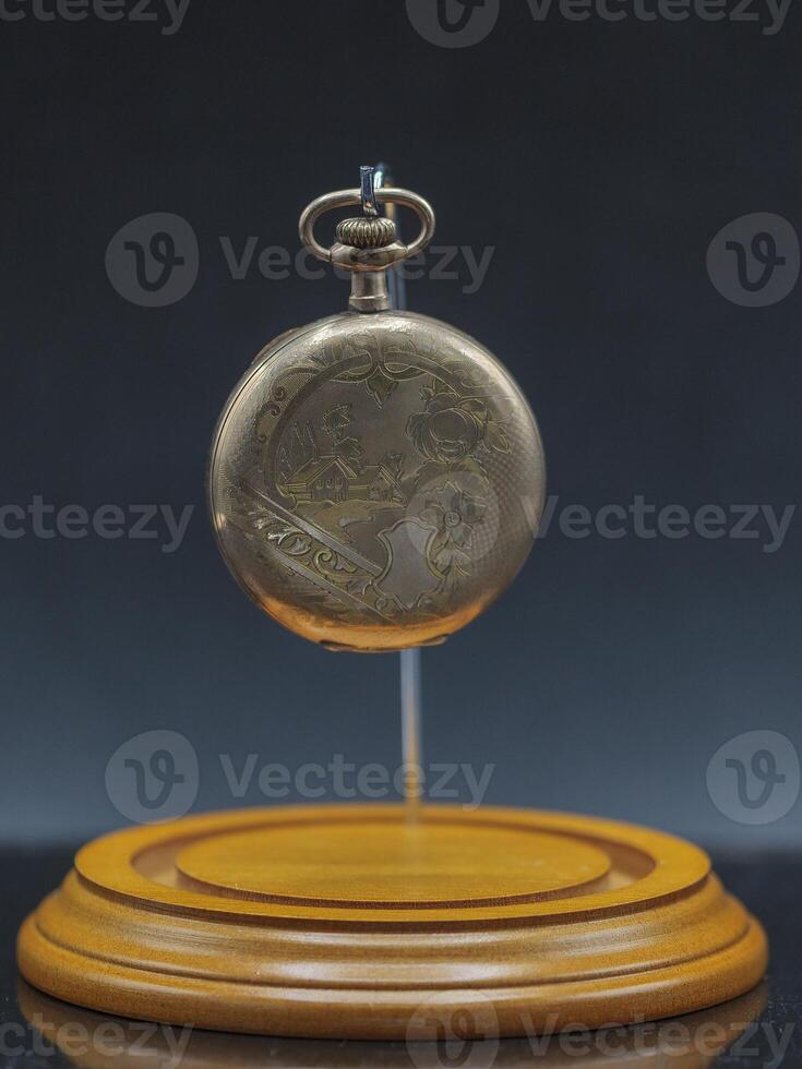 old gold pocket watch a family heirloom from an unclear lineage ago in its display case without the dome photo