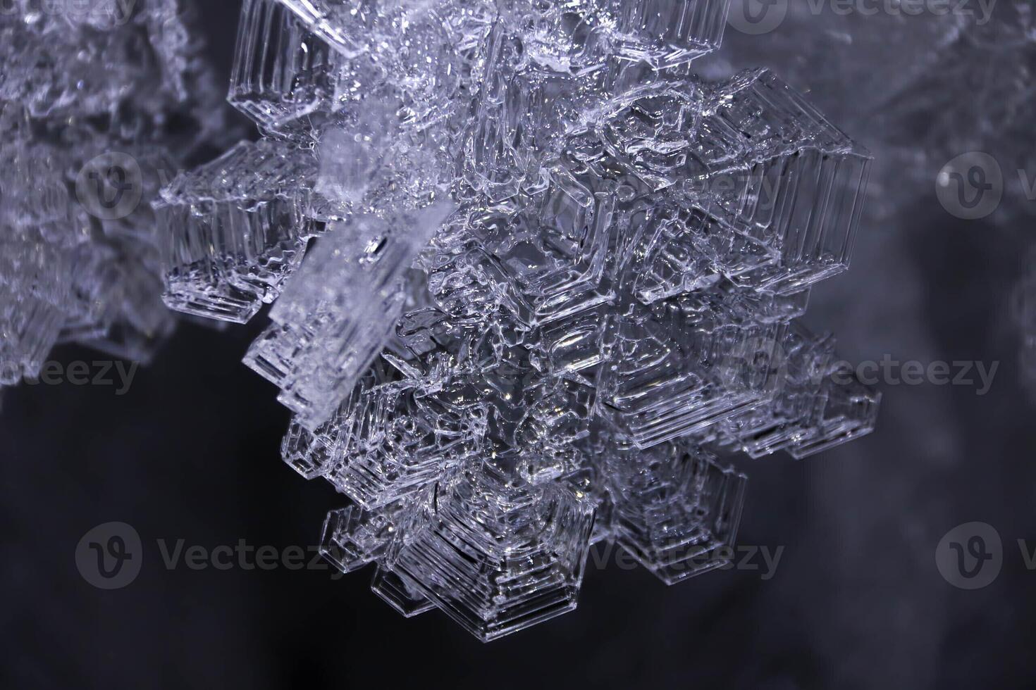 Crop Group of Abstract Giant Frost Crystal Clear Snowflakes with Winter Patterns Cold Shaded highlighted black dark background. Ice petals cover lights in background in blurred focus with copy space photo