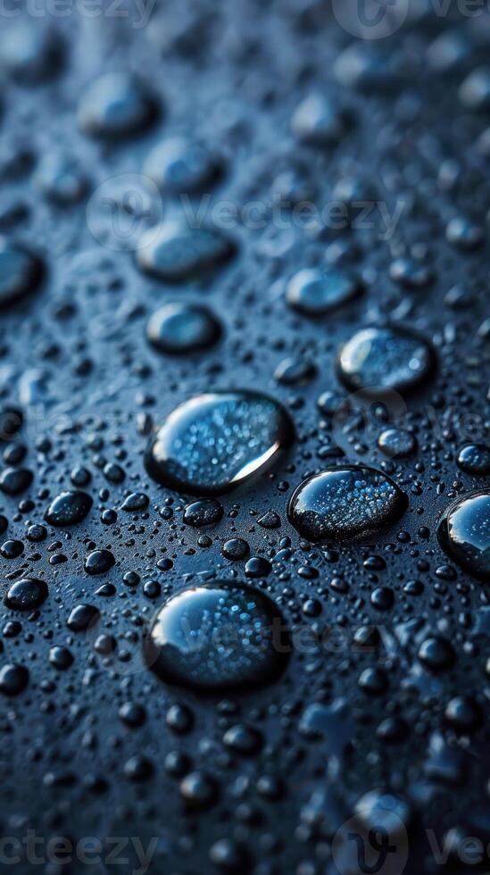 Close-up view of water droplets resting on a dark surface photo
