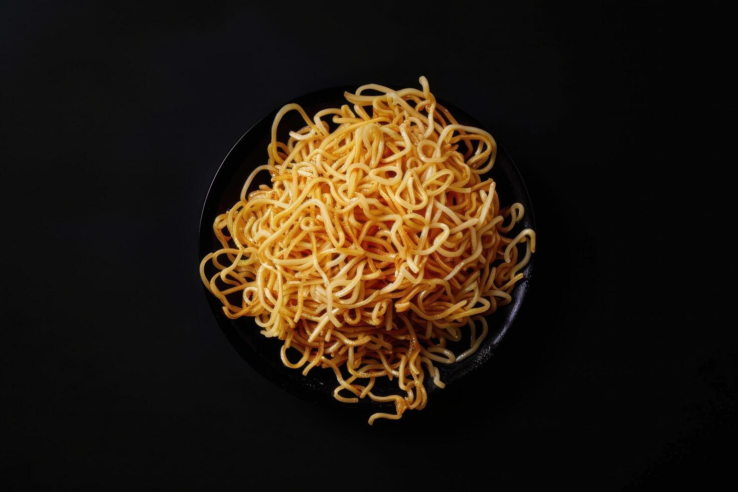A Plate of Golden Noodles on a Black Background photo