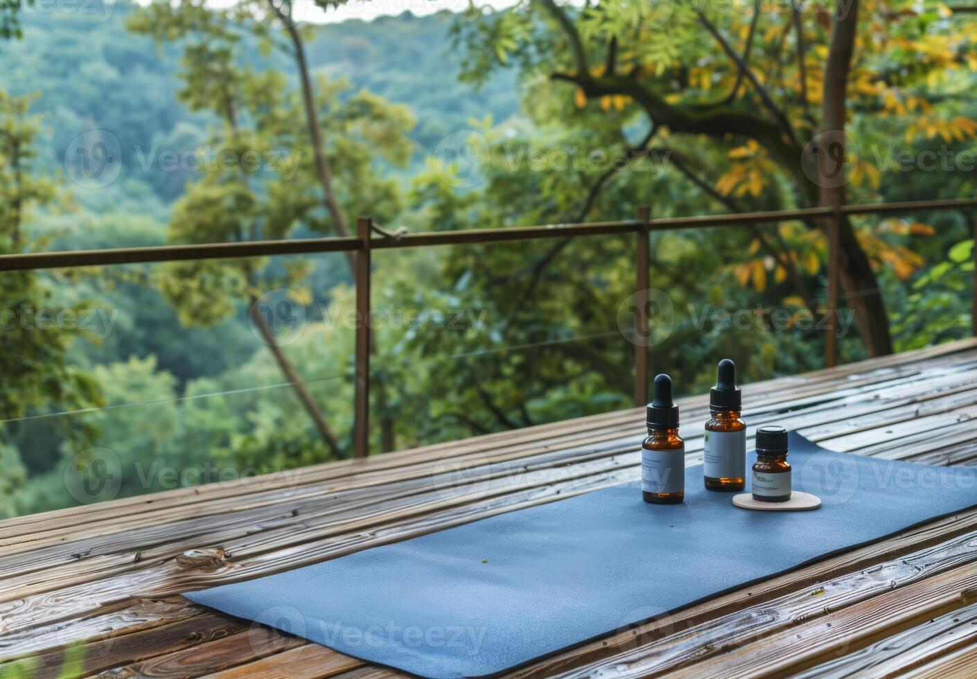 A serene nature scene featuring a yoga mat and essential oils set up on a wooden deck overlooking a peaceful forest, symbolizing holistic health and wellness photo