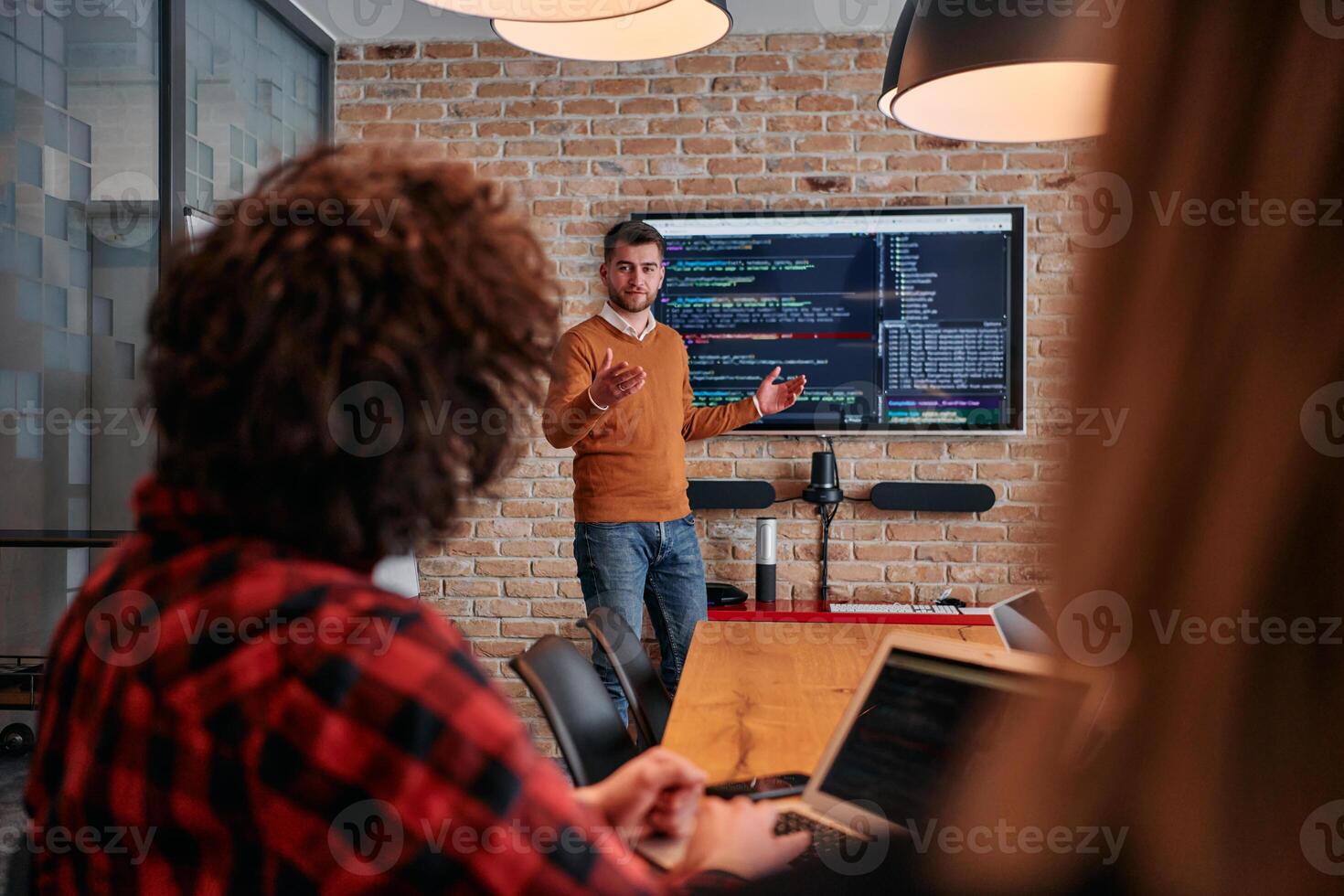In a corporate setting businessman leads a meeting, passionately presenting a business plan to his attentive team, fostering collaboration and strategic thinking photo