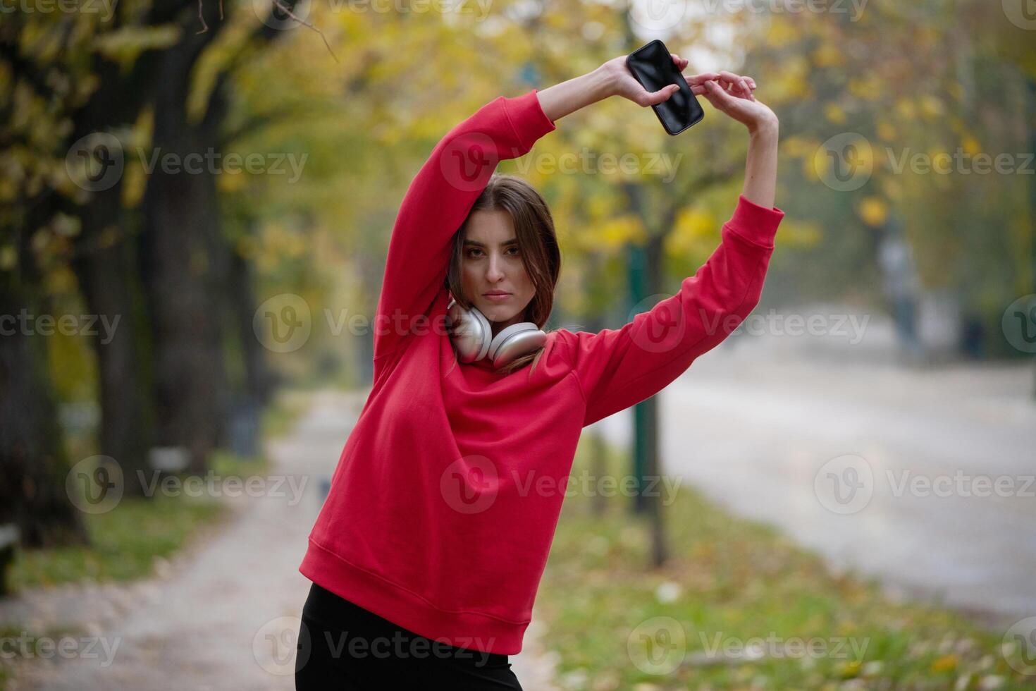Athletic young woman taking a breath and relaxing after jogging and stretching. Woman Training and Workout Exercises On Street. photo