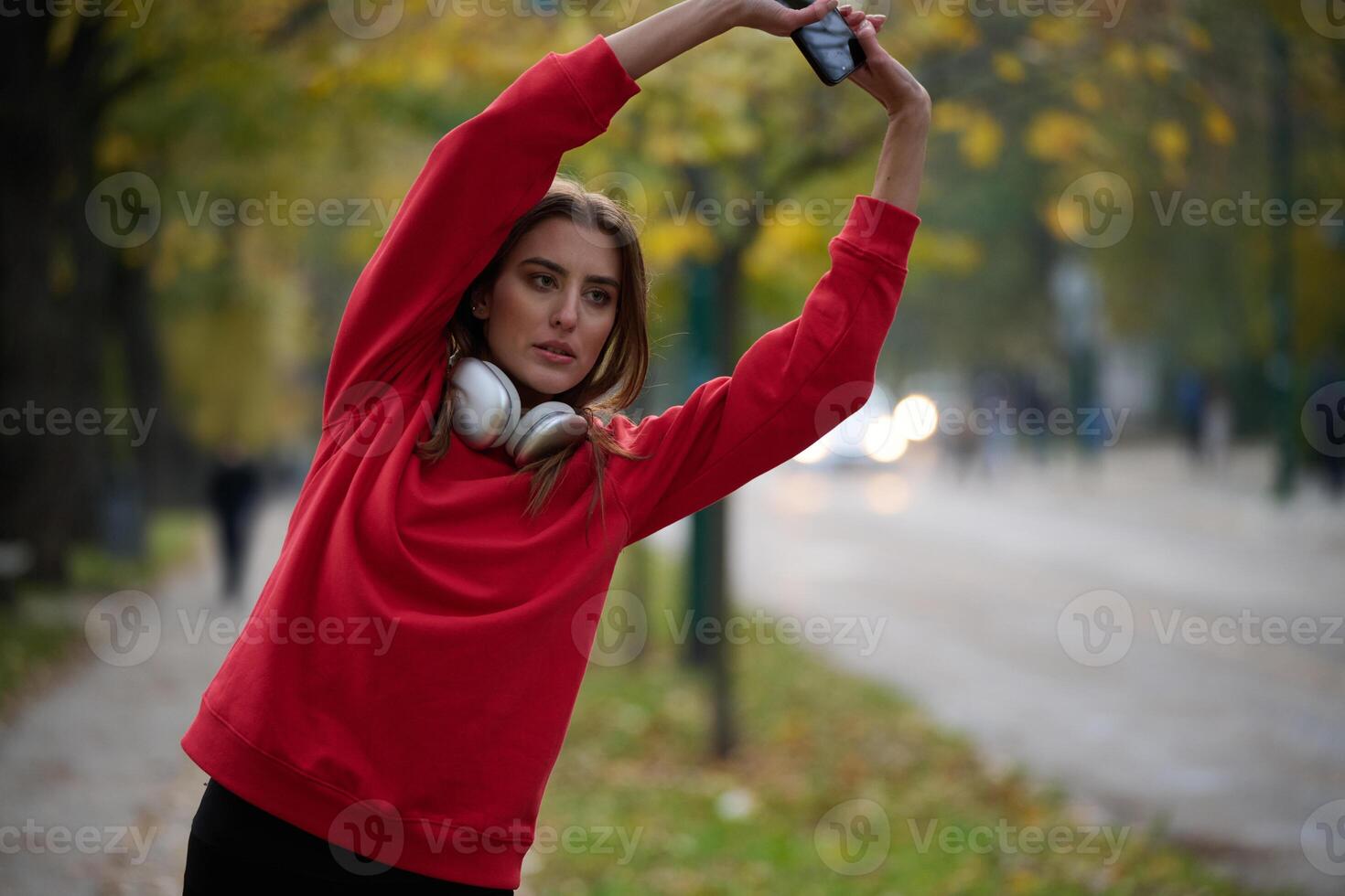 Athletic young woman taking a breath and relaxing after jogging and stretching. Woman Training and Workout Exercises On Street. photo