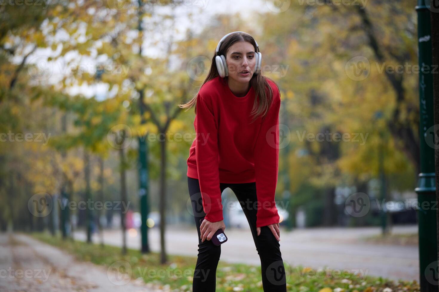 Athletic young woman taking a breath and relaxing after jogging and stretching. Woman Training and Workout Exercises On Street. photo