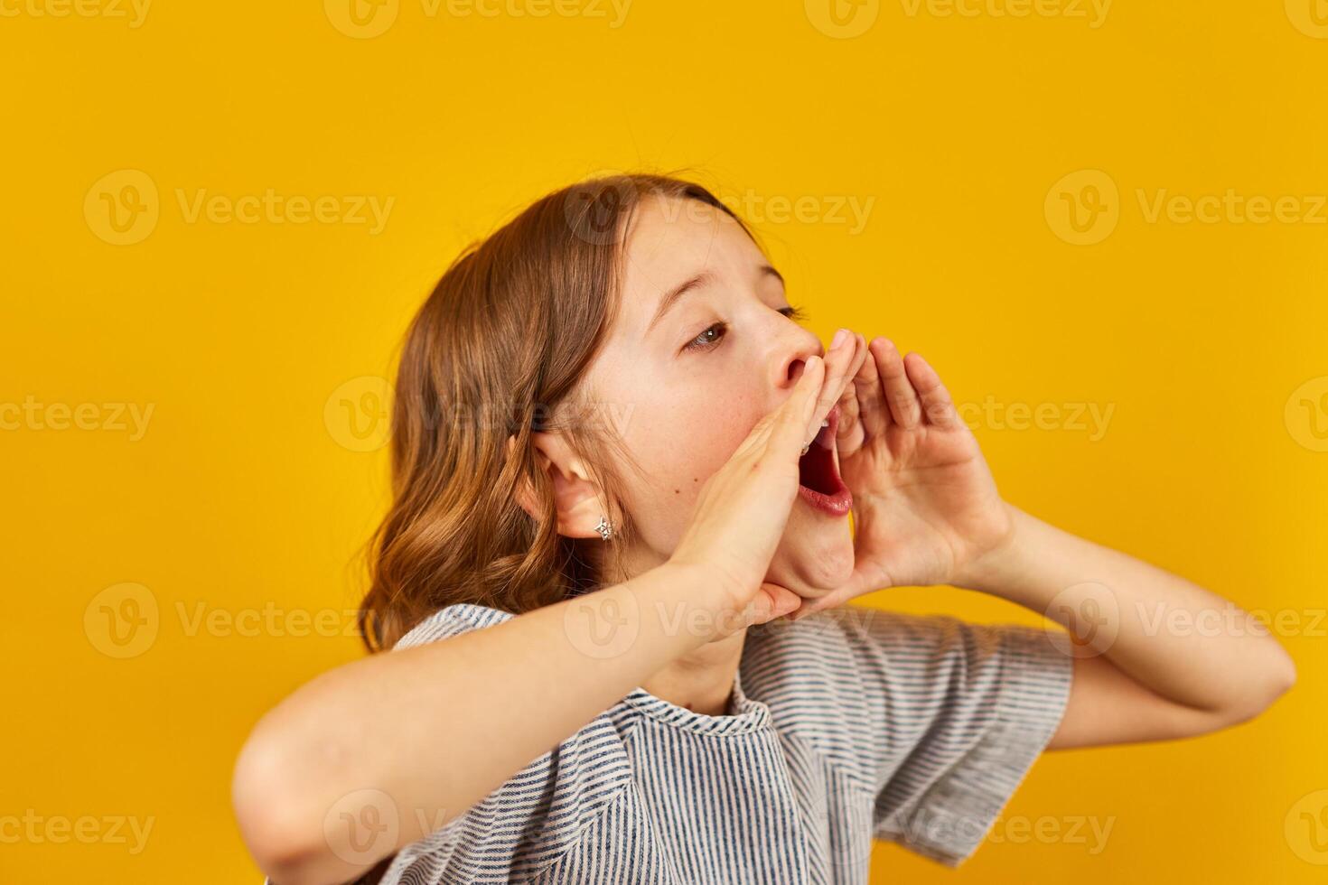Teenage Schoolgirl Shouting an Announcement Against a Bright Yellow Background photo