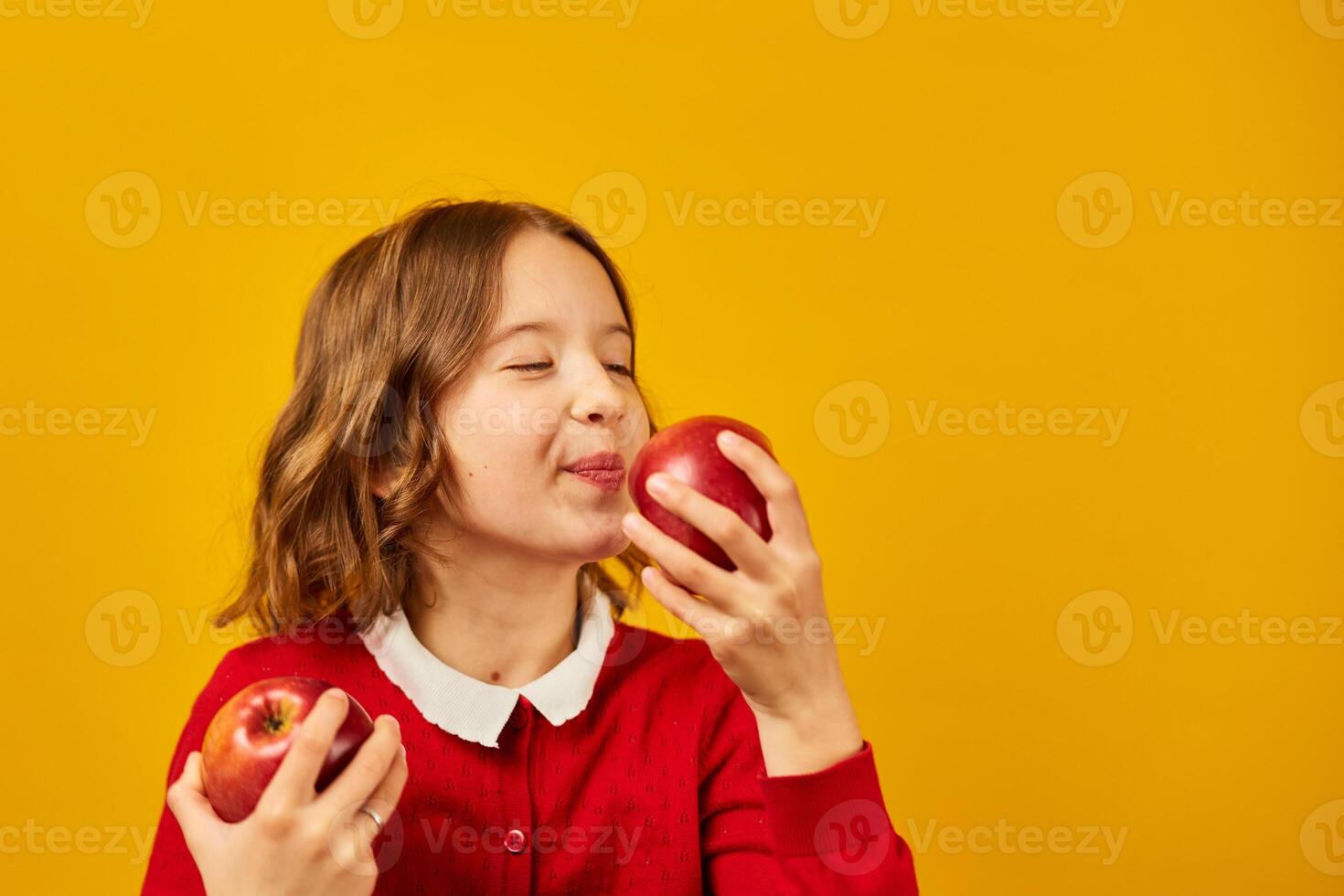 A schoolgirl holding two apples in her hands photo
