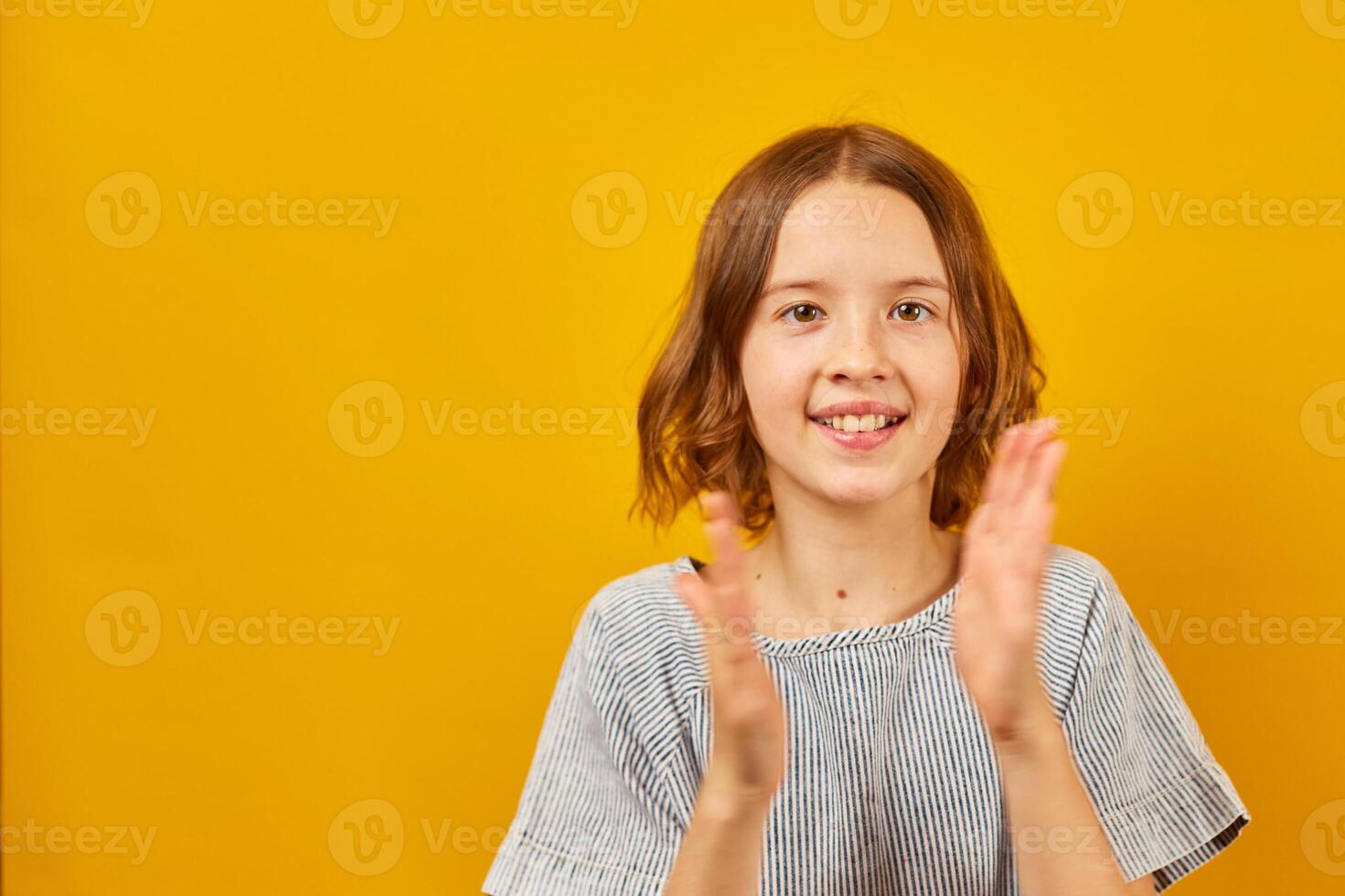 Teenage Schoolgirl Clapping Hands Against a Bright Yellow Background During Daytime photo