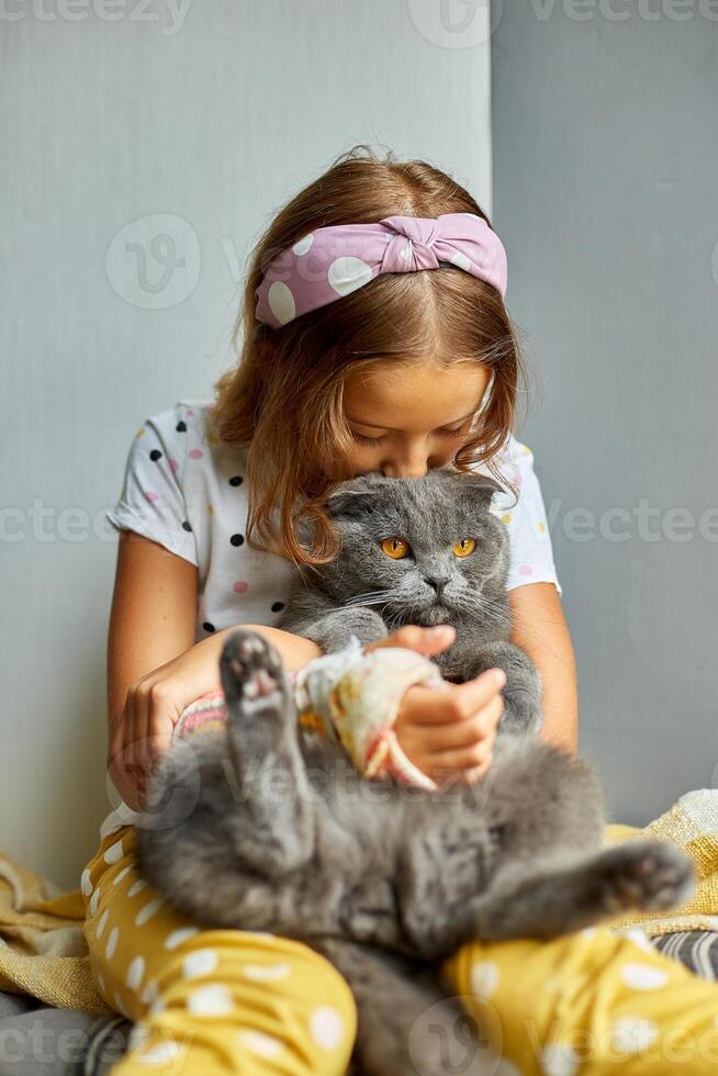 Teen girl with a broken arm orthopedic cast play with cat photo