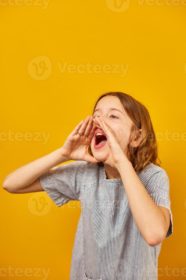 Teenage Schoolgirl Shouting an Announcement Against a Bright Yellow Background photo